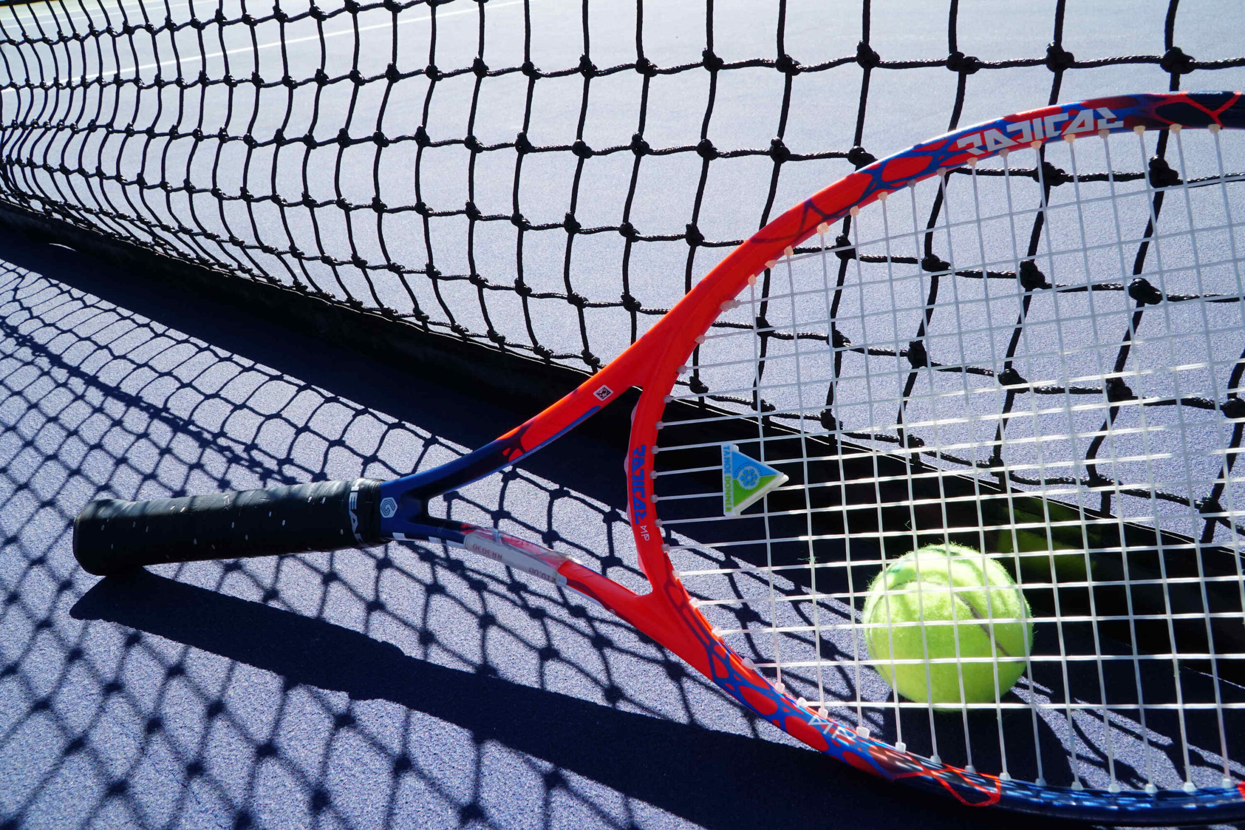 Tennis racket and ball on court, part of a vacation rental experience in Truckee.