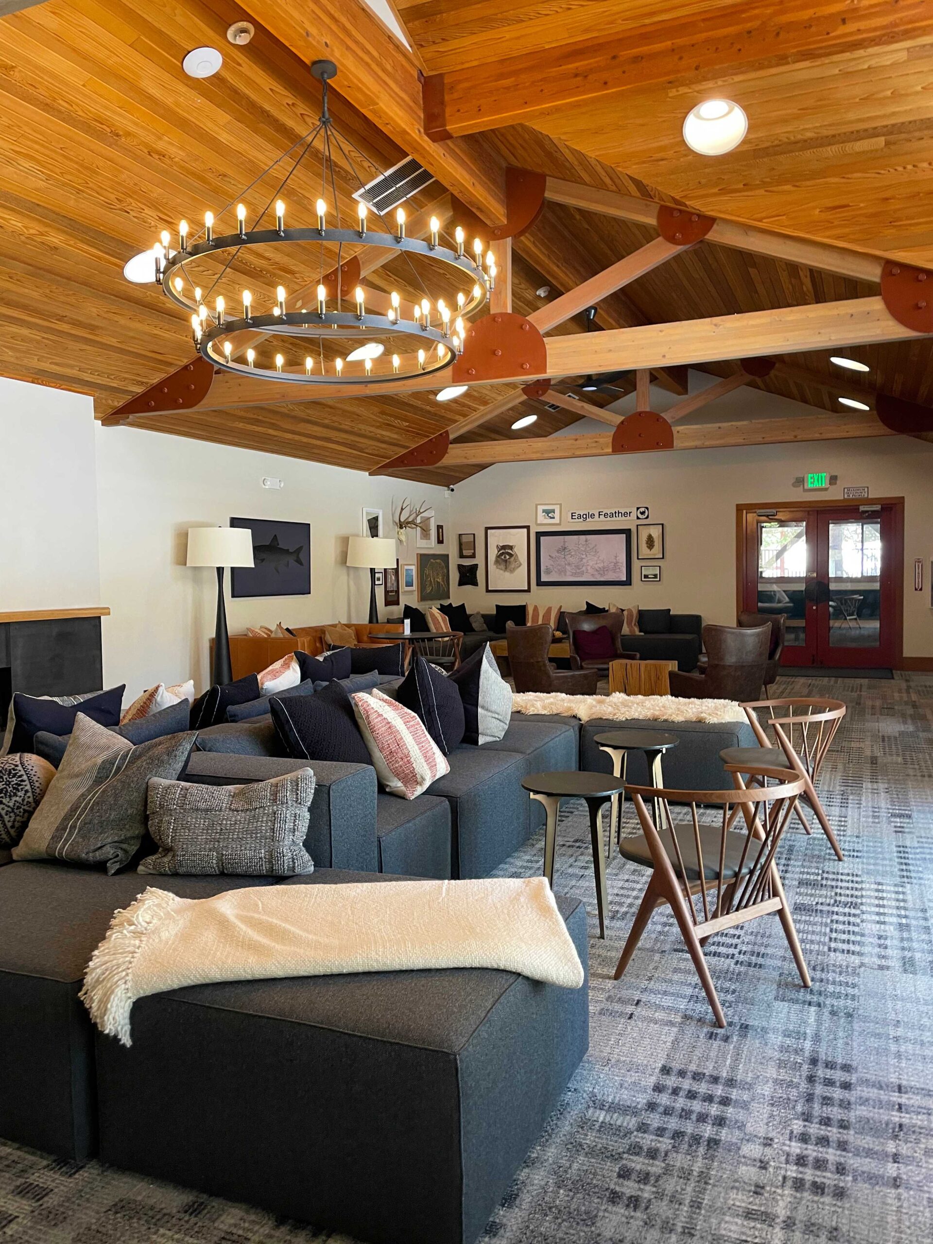 Modern living area in a Truckee vacation rental, featuring cozy seating, wooden ceiling, and a circular chandelier.