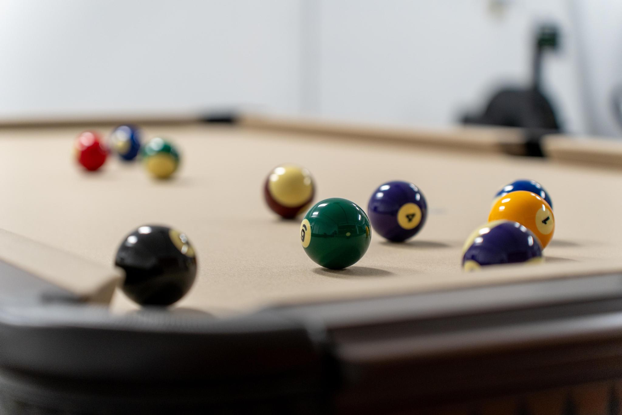 Pool table with balls in a Truckee vacation rental, offering relaxing entertainment.