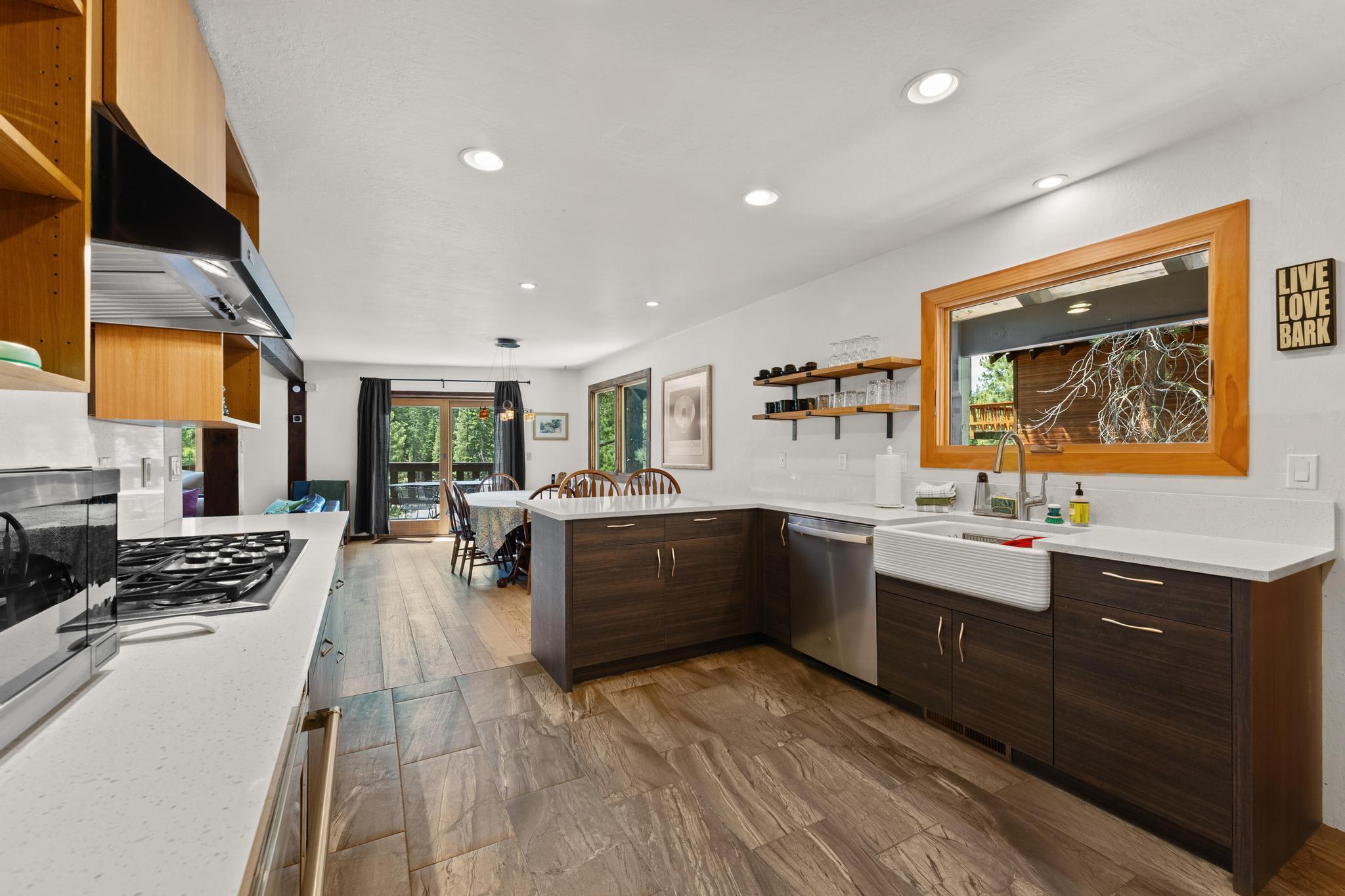 Stylish kitchen in a Tahoe Vista vacation rental with modern appliances and a view of the dining area and greenery.