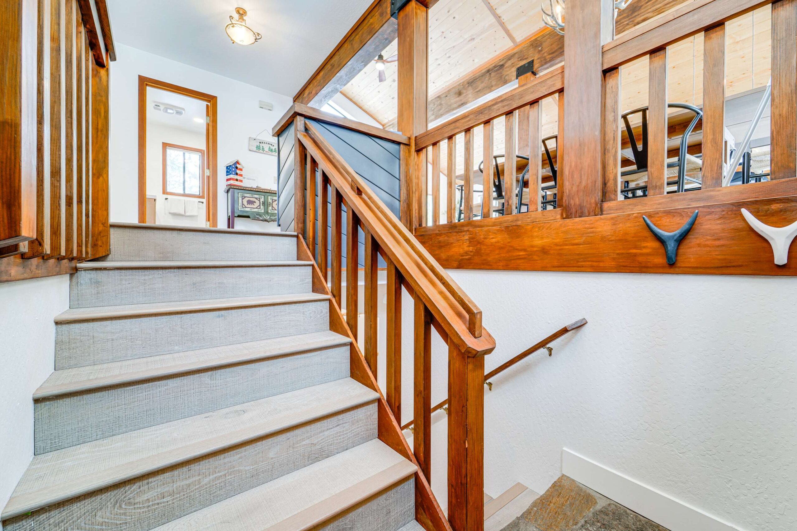 Staircase in a rustic Truckee vacation rental, featuring wooden railings and a decoratively lit interior.