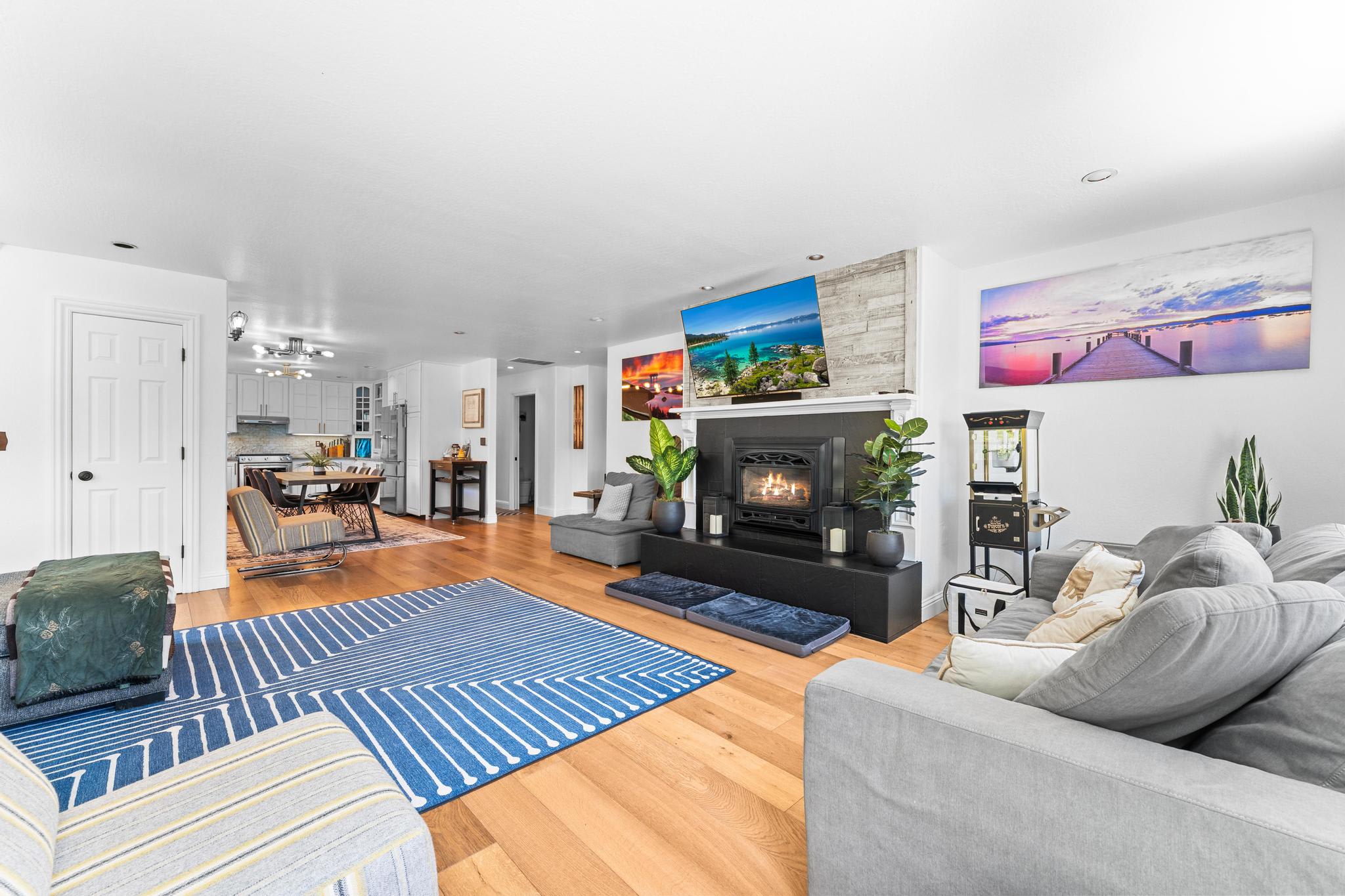 Spacious living room in a Truckee vacation rental with cozy fireplace, modern decor, and open kitchen area.