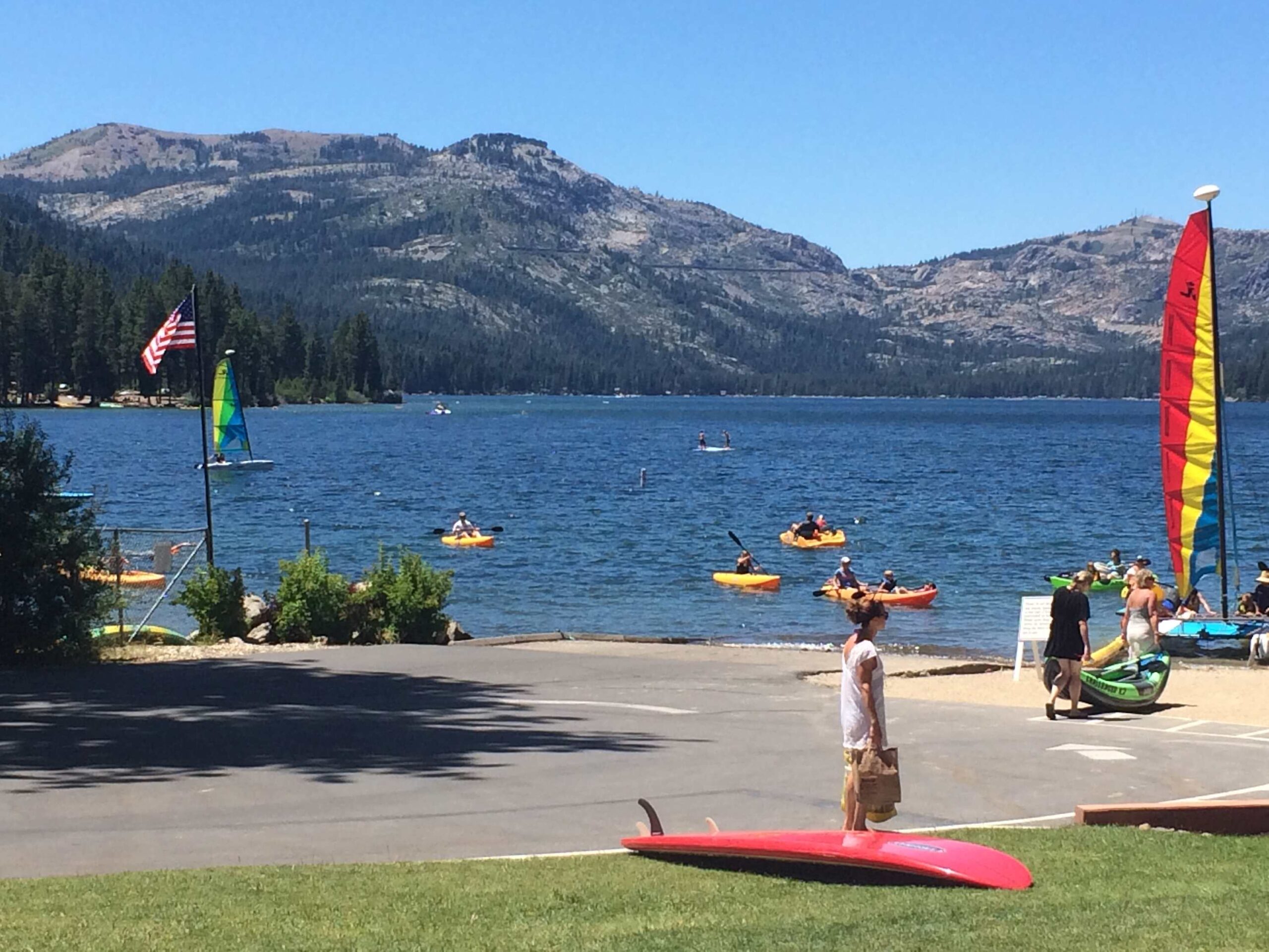 People kayaking on a lake with mountainous backdrop in Truckee near a vacation rental.