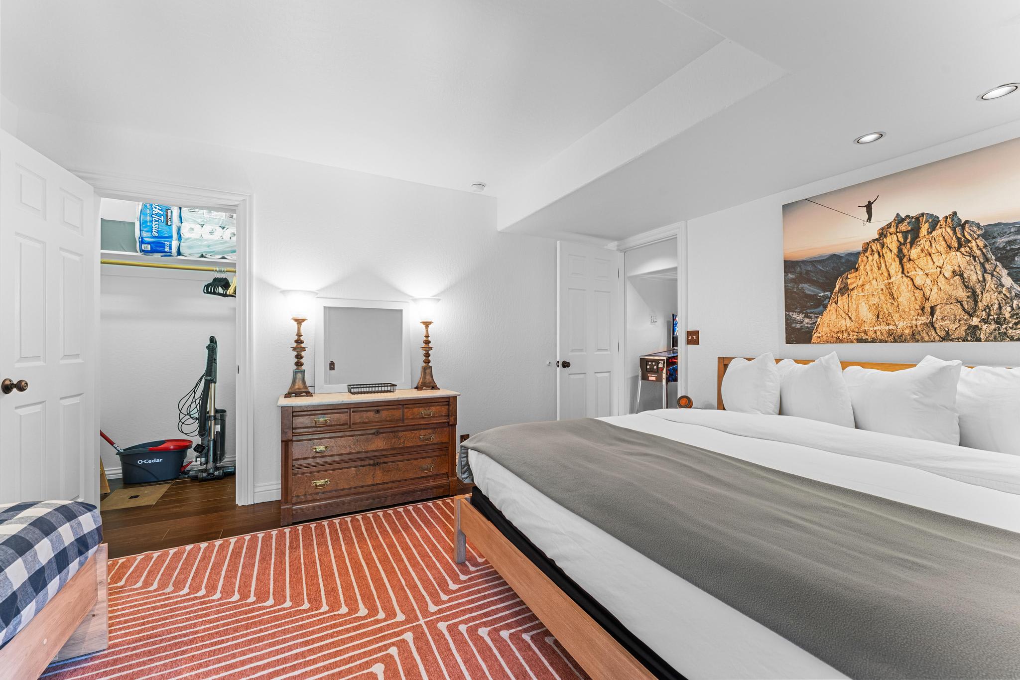 Cozy bedroom in Truckee vacation rental with a king bed, dresser, artwork, and closet.