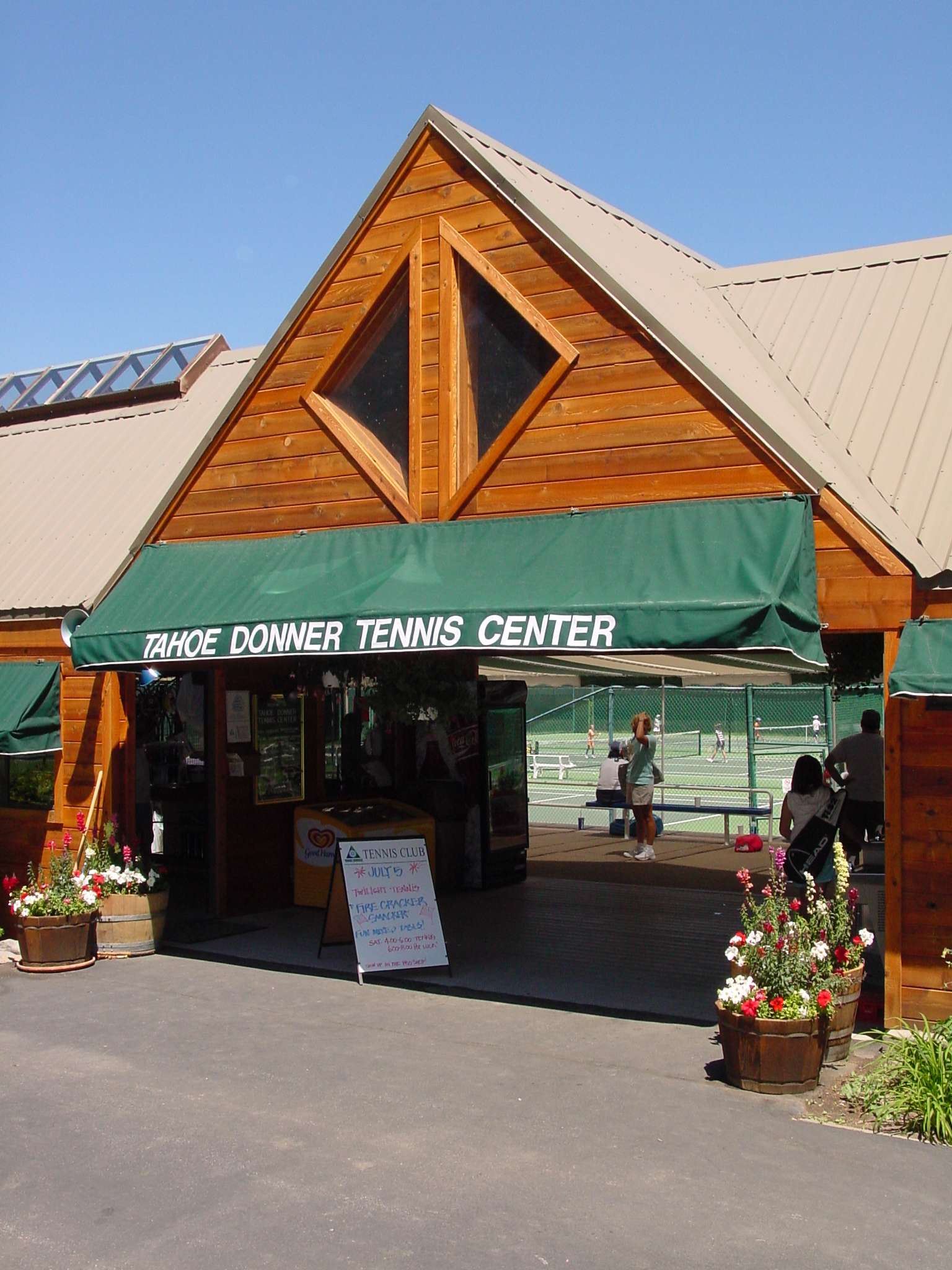 Truckee vacation rental near Tahoe Donner Tennis Center, with wooden facade and blooming flowers outside the entrance.