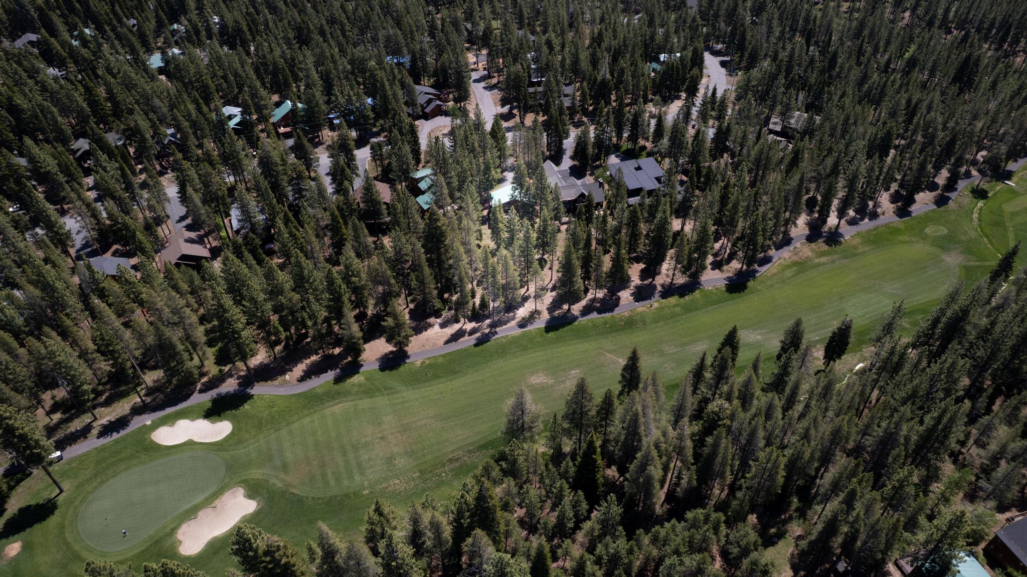 Aerial view of vacation rental homes surrounded by trees near a golf course in Truckee.