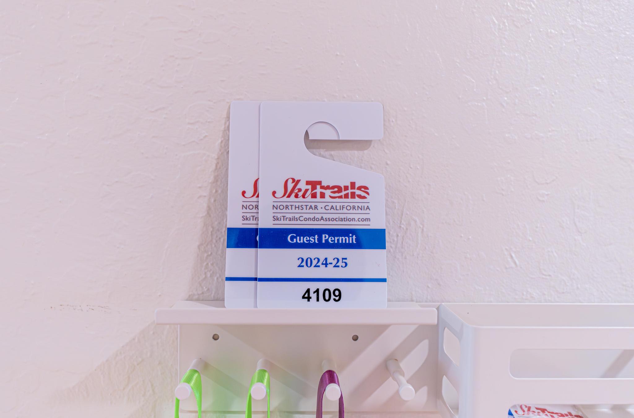 Guest permit for a Truckee vacation rental displayed on a white shelf, marked 2024-25, with colorful hooks below.