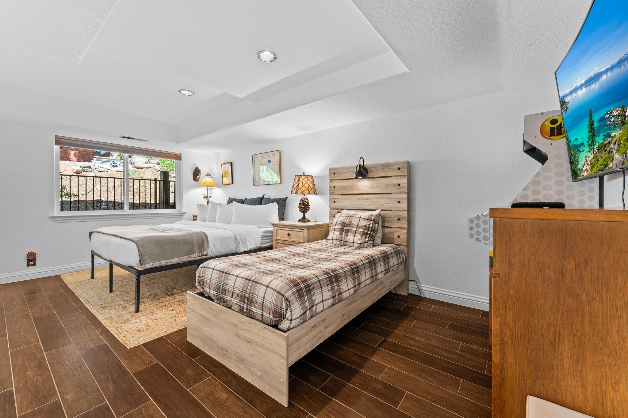 Cozy Truckee vacation rental bedroom with two beds, a window view, and rustic decor.