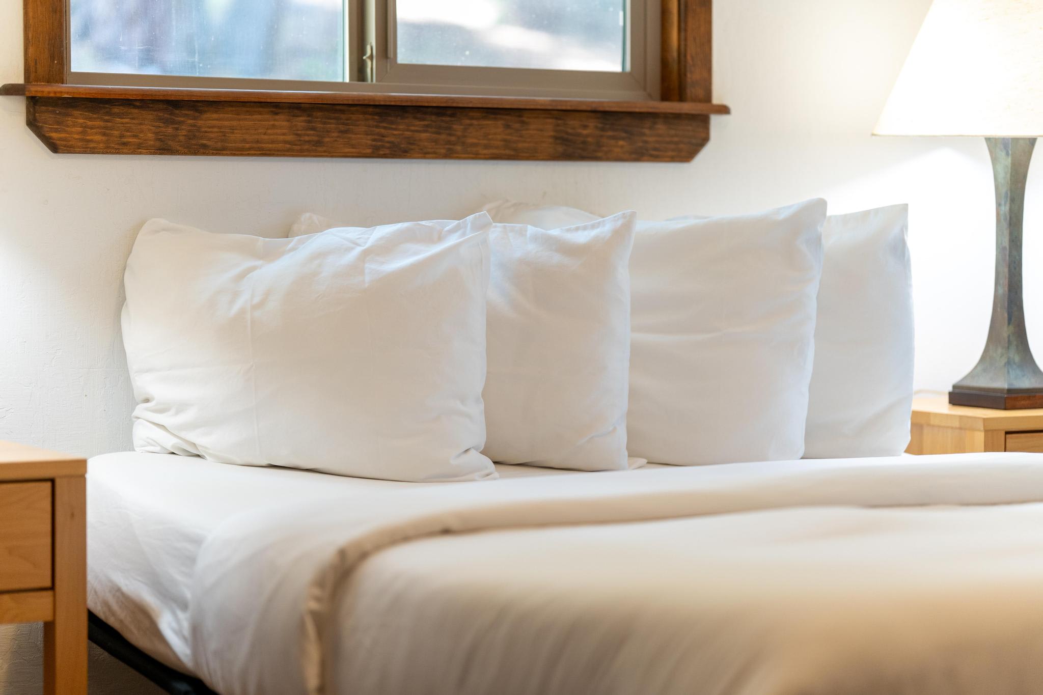 Cozy bed with white pillows and wooden accents in a Tahoe Vista vacation rental.
