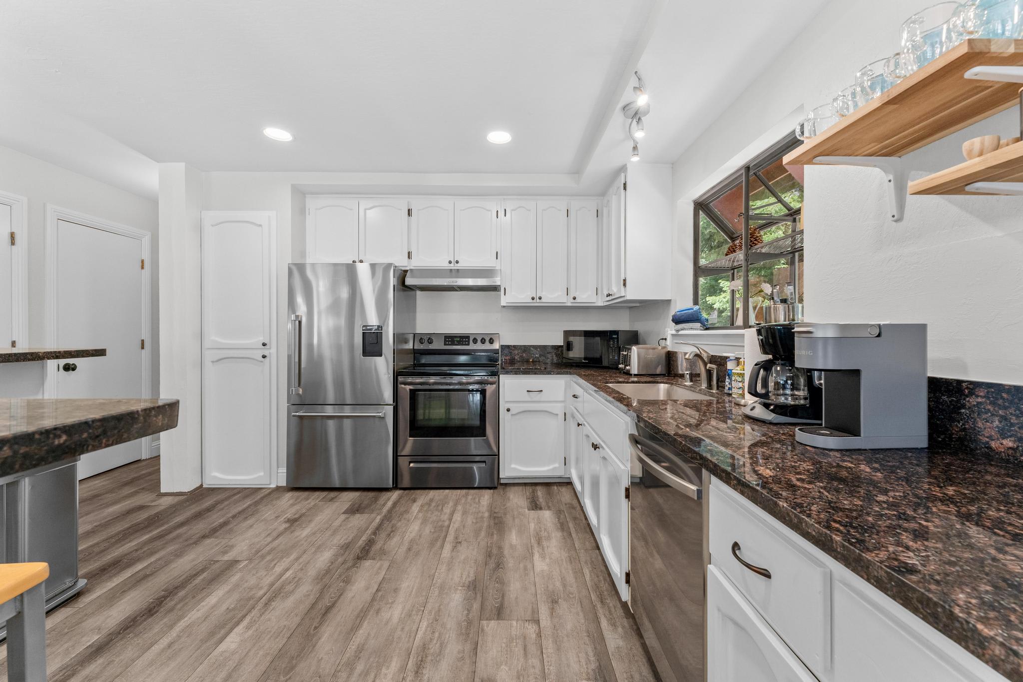 Modern kitchen in a Tahoe Vista vacation rental, featuring stainless steel appliances and granite countertops.