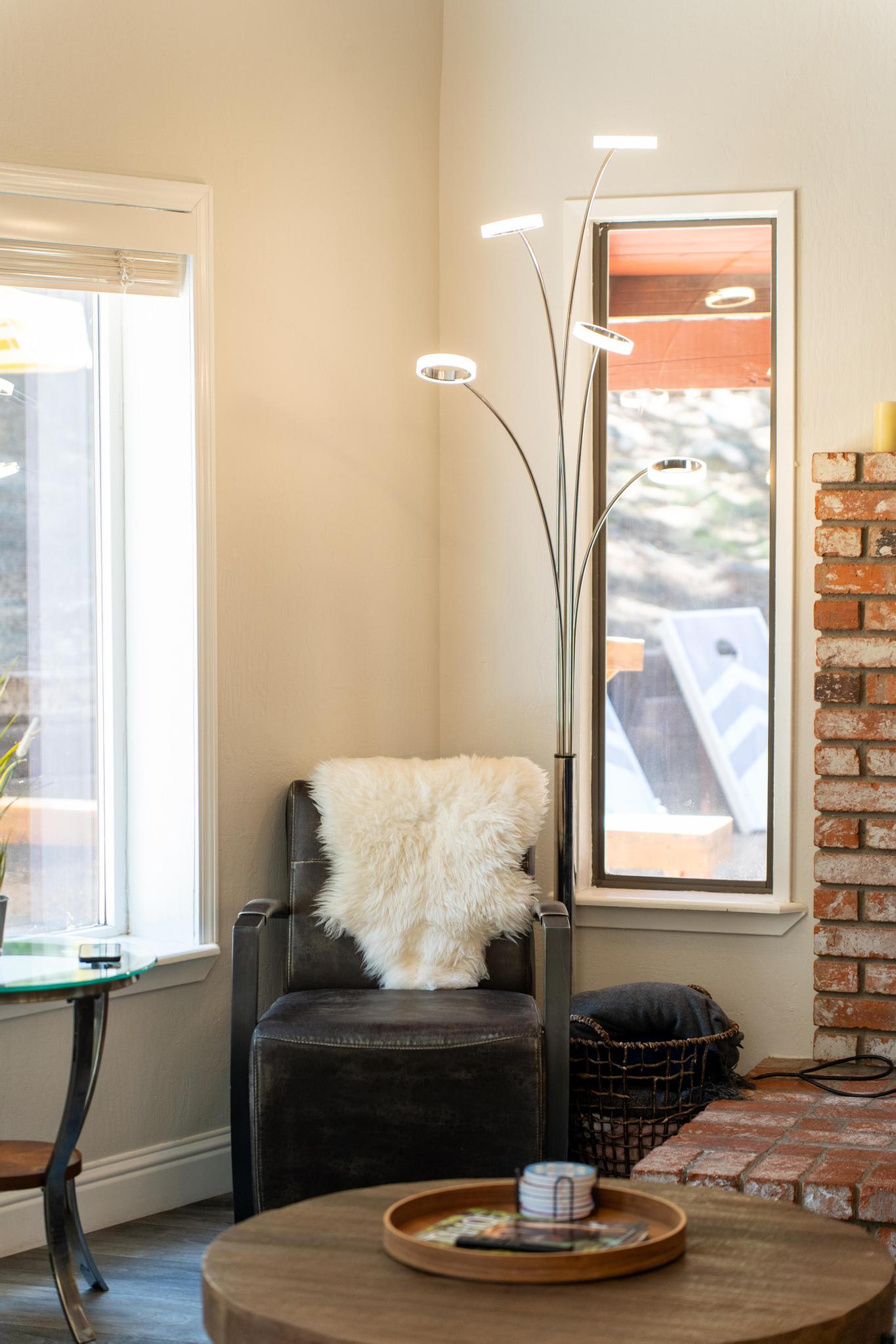 Cozy Tahoe Vista vacation rental interior with armchair, fur throw, modern lamp, and brick fireplace.
