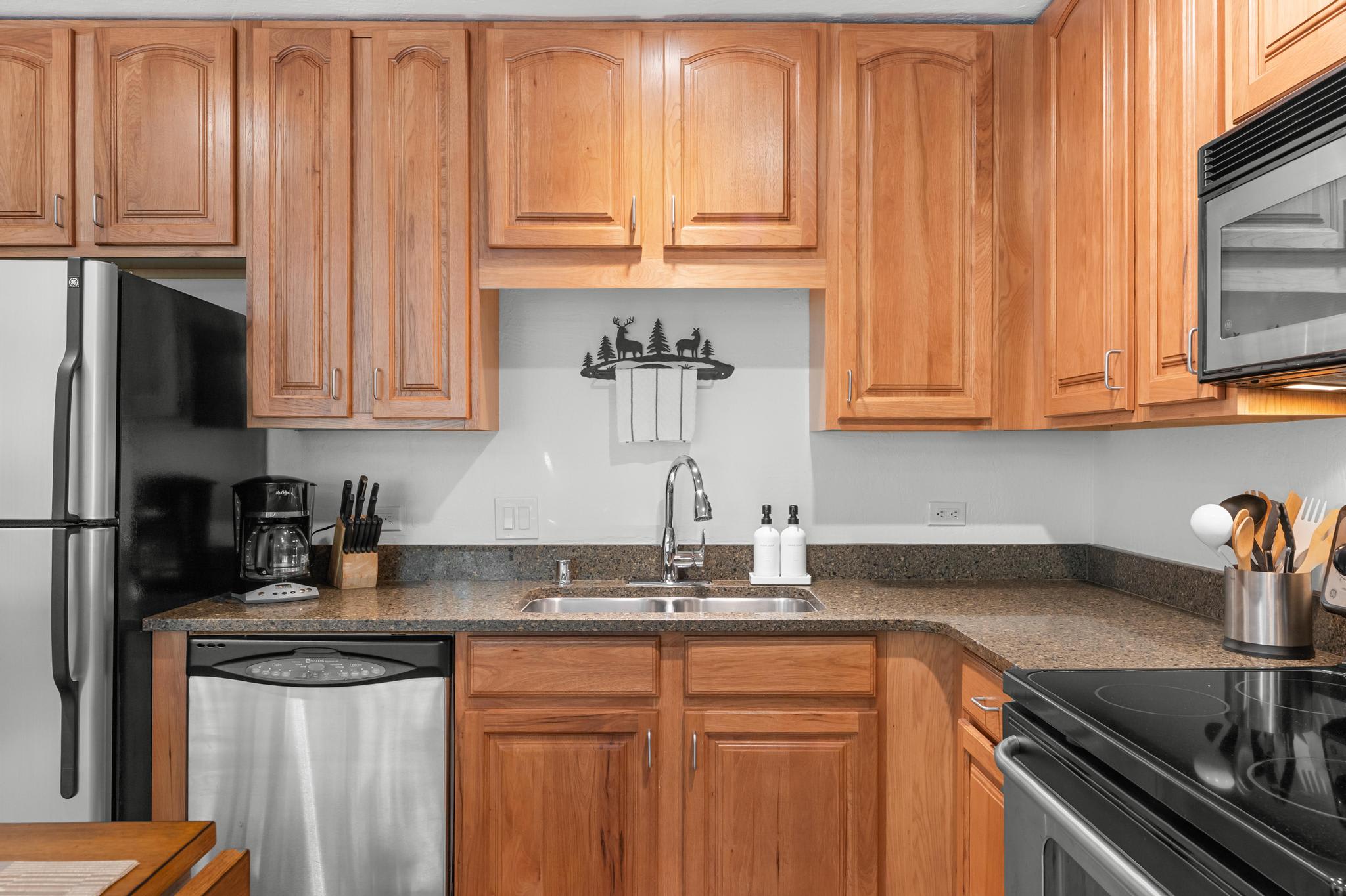 Cozy kitchen in a Truckee vacation rental with wooden cabinets, stainless appliances, and dark countertops.