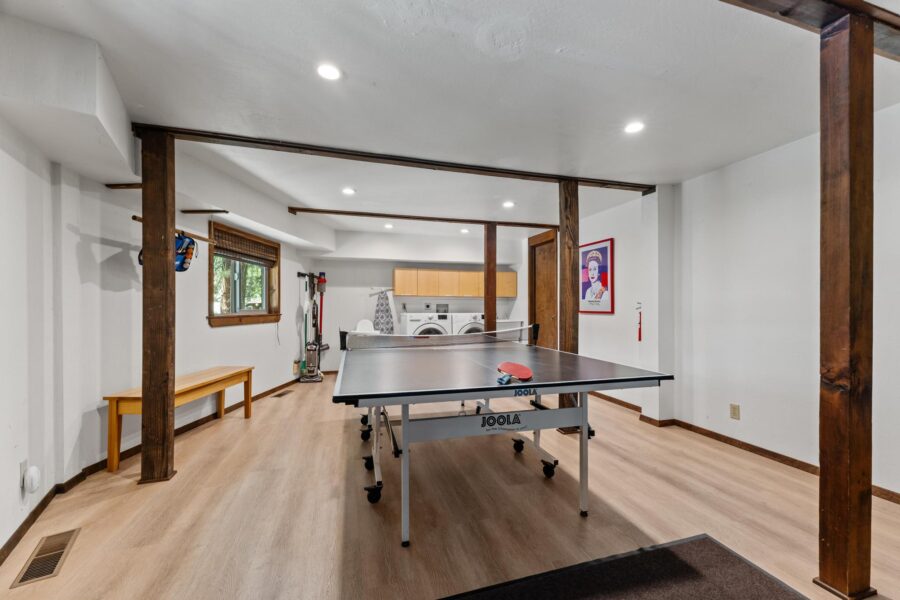 Game room in Tahoe Vista vacation rental featuring a ping pong table, laundry area, and framed art on the wall.
