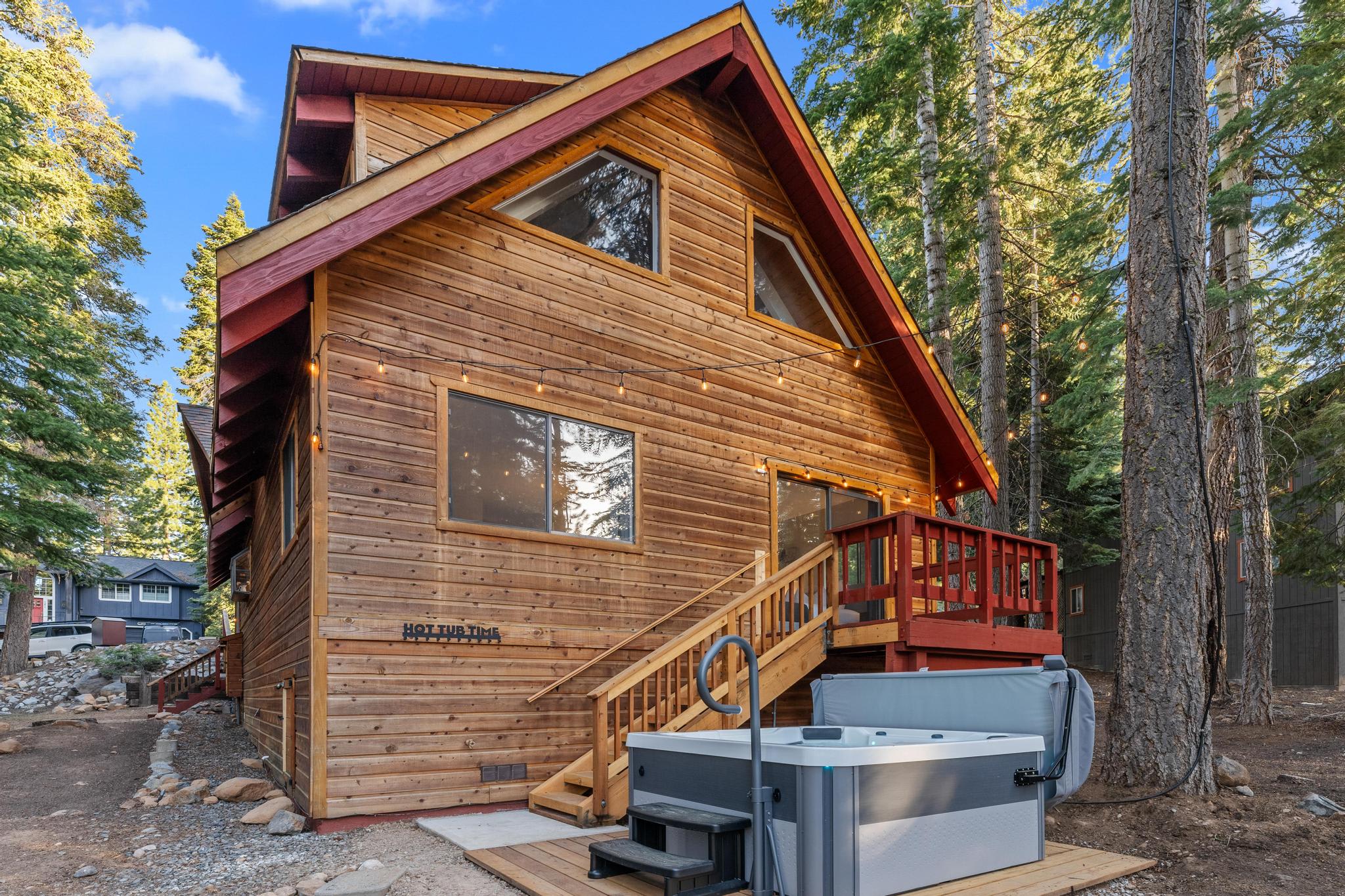 Cozy wood cabin in Tahoe Vista, surrounded by trees, featuring a deck and hot tub; ideal vacation rental.