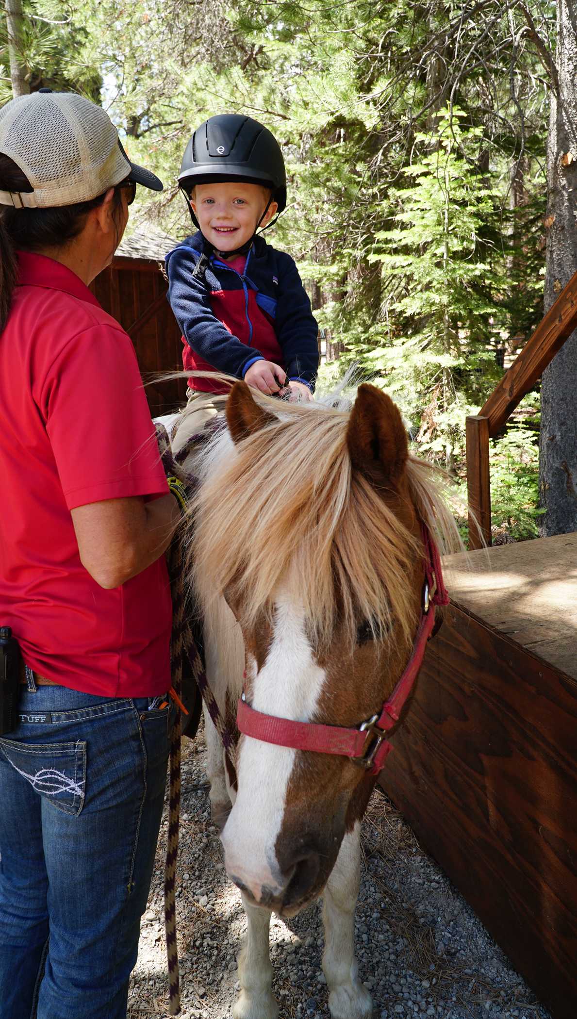 Child on a pony ride in Truckee forest, guided by an instructor. Ideal activity for a vacation rental experience.