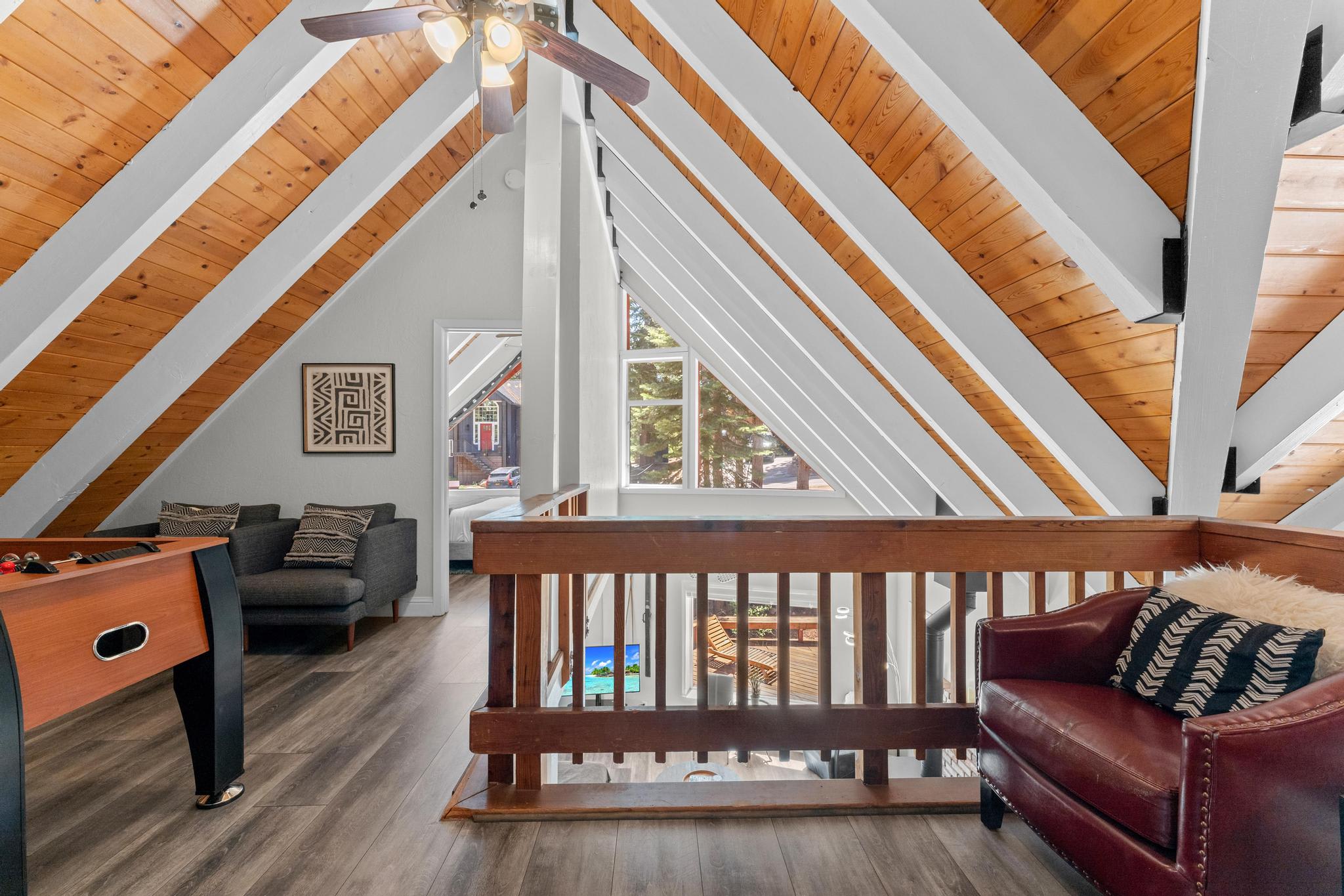 A-frame loft in Tahoe Vista vacation rental with wood ceiling, cozy seating, and bright window view.