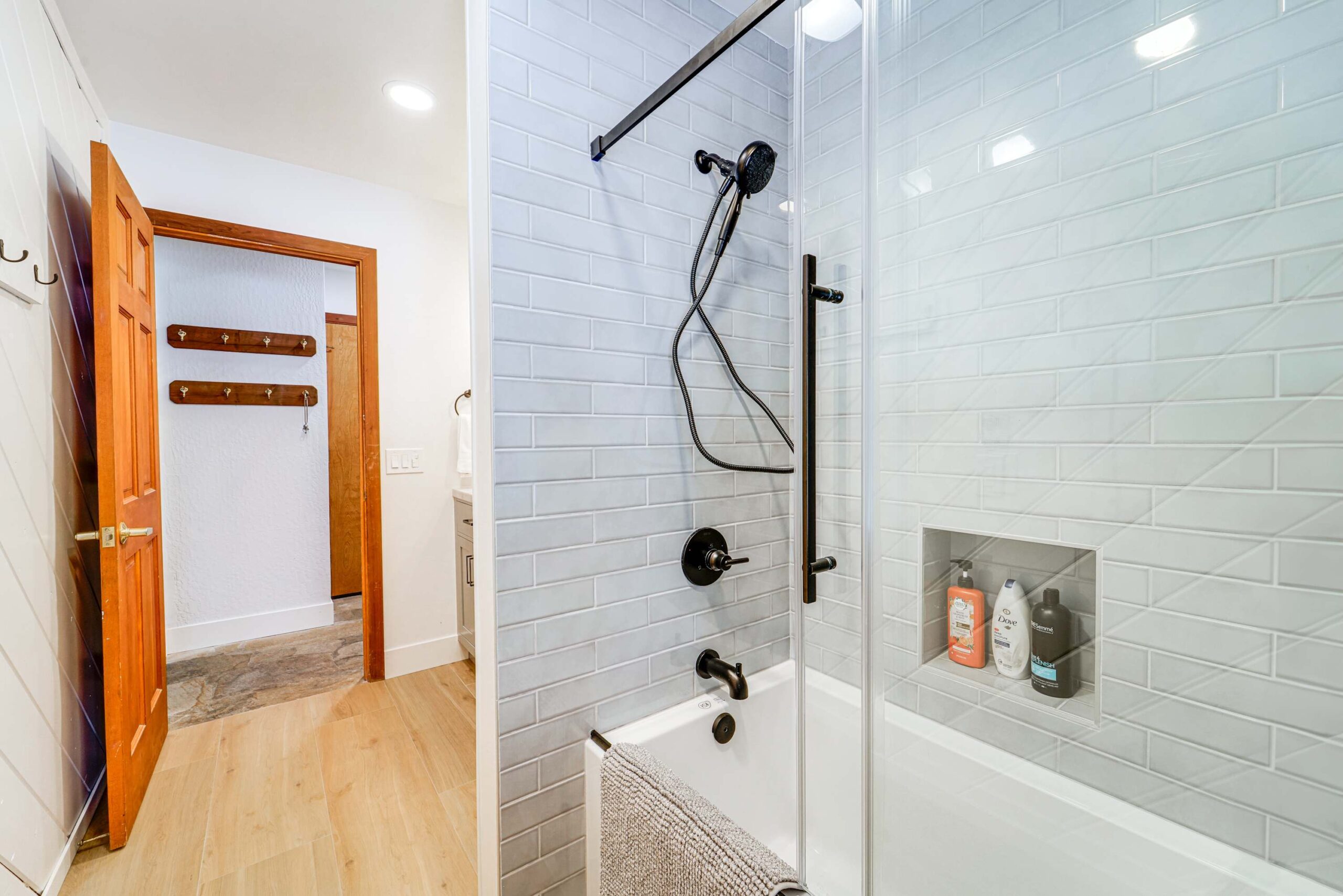 Modern bathroom with glass shower in a Truckee vacation rental, featuring sleek fixtures and wooden doors.