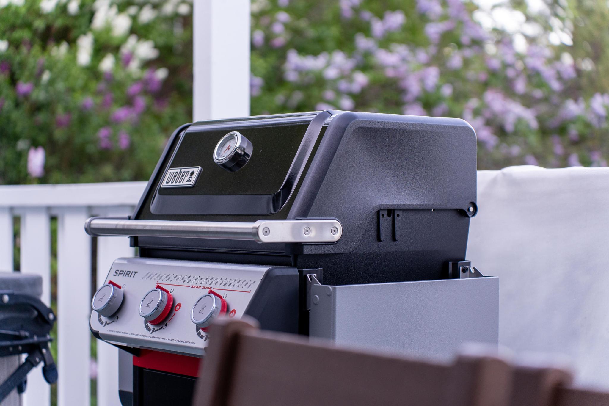 Barbecue grill on a deck in Truckee vacation rental, surrounded by lush green trees in the background.