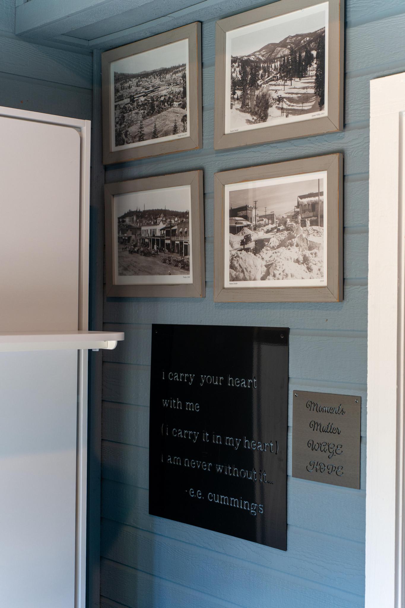 Wall art in a Truckee vacation rental showcasing framed vintage photos and inspirational quotes on a blue wall.