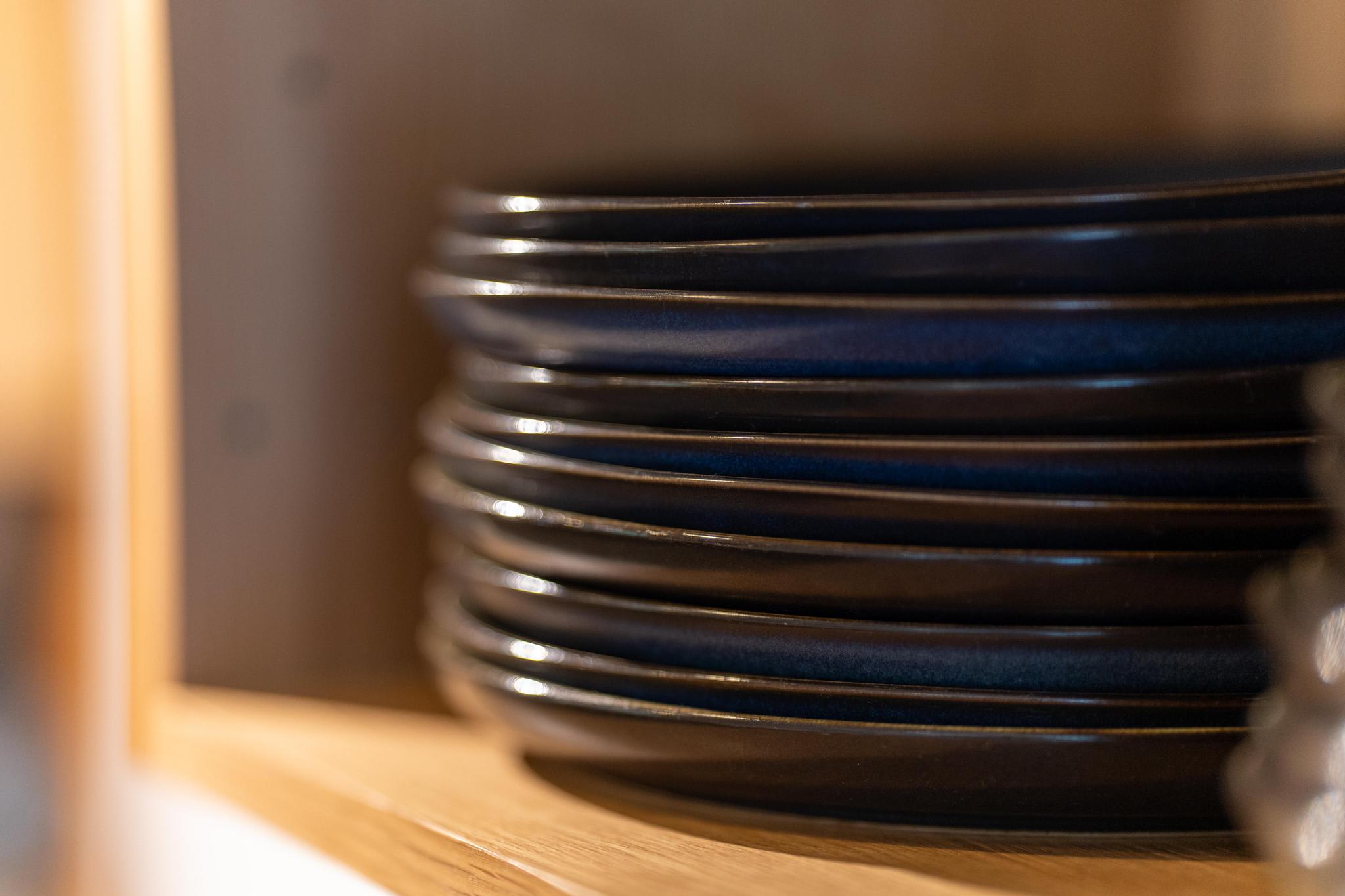 Stack of black plates in a kitchen cabinet of a Tahoe Vista vacation rental.
