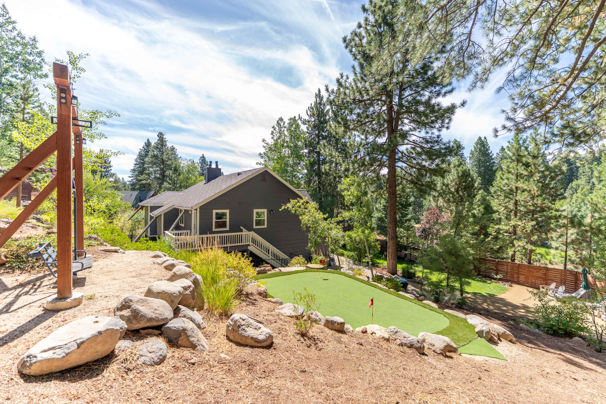 Rustic Truckee vacation rental with a modern cabin, surrounded by trees, featuring a mini-golf course.
