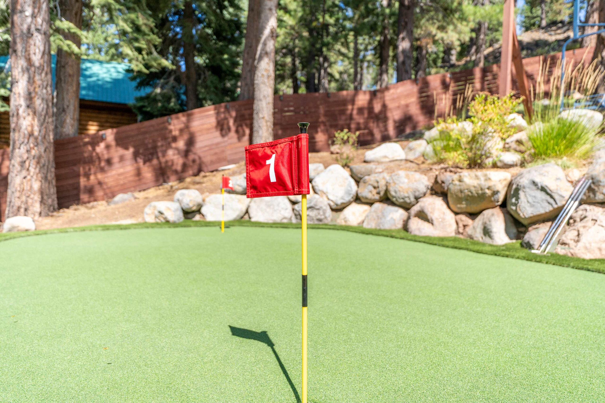 Mini-golf course at a Truckee vacation rental, featuring rocks and trees in the background.