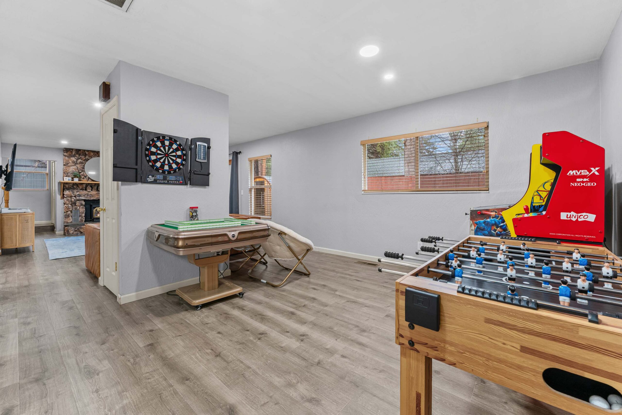 Game room in a Truckee vacation rental featuring a foosball table, arcade game, and dartboard for entertainment.