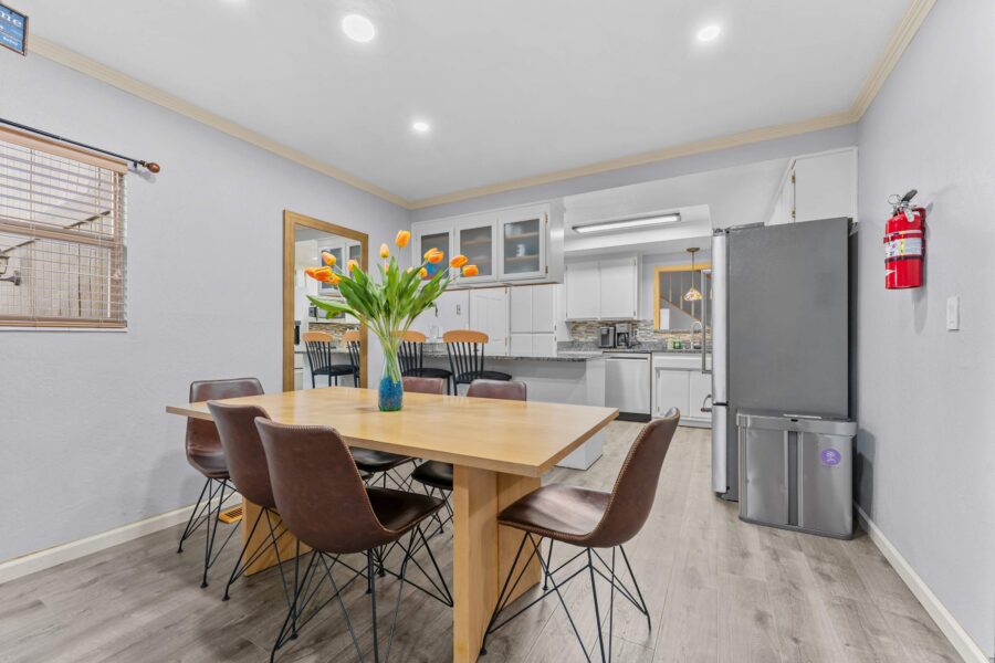 Dining area in a Truckee vacation rental, featuring a wooden table, brown chairs, and tulips in a vase.