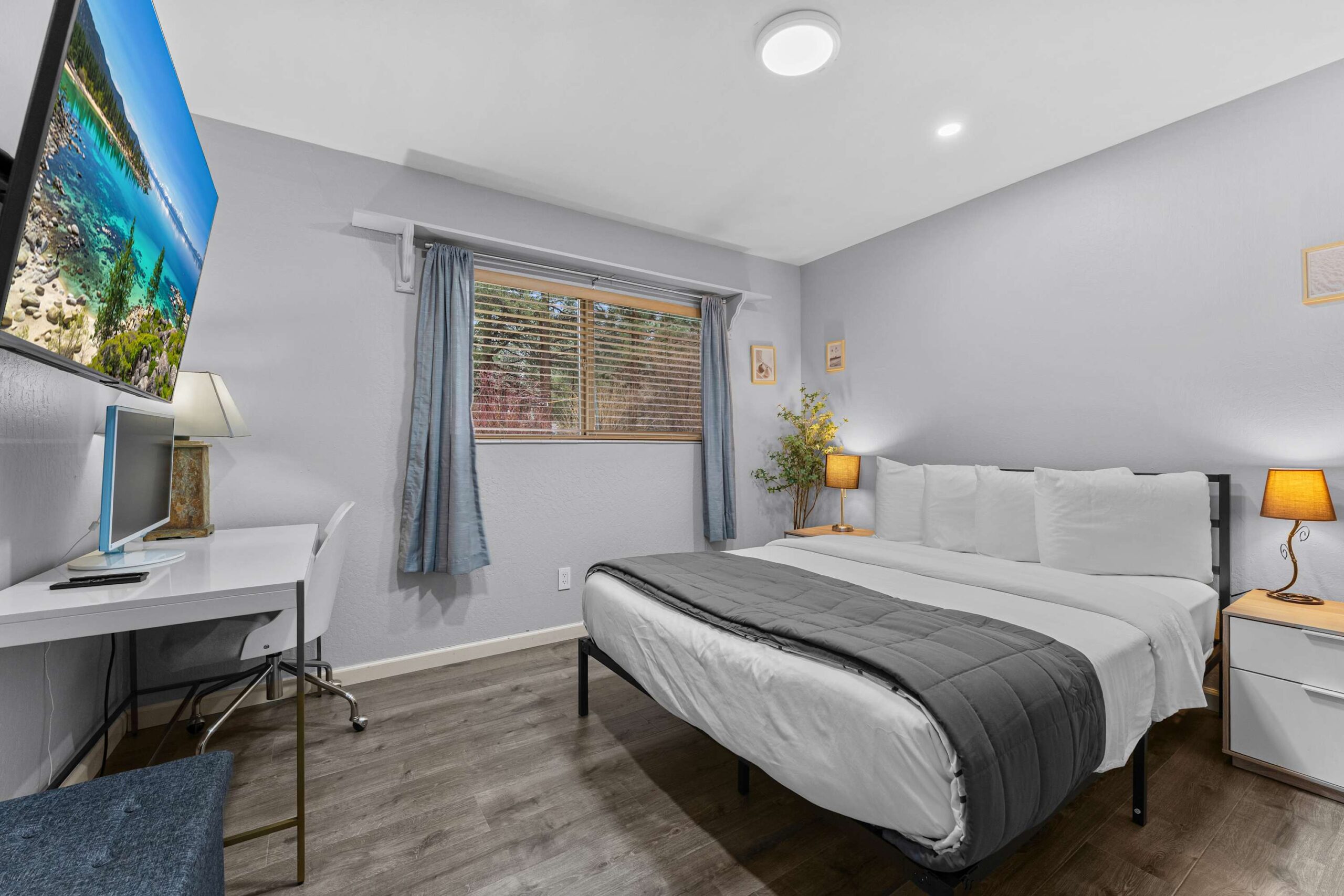 Bedroom in a Truckee vacation rental with a cozy bed, desk, and window view, featuring minimalist decor.