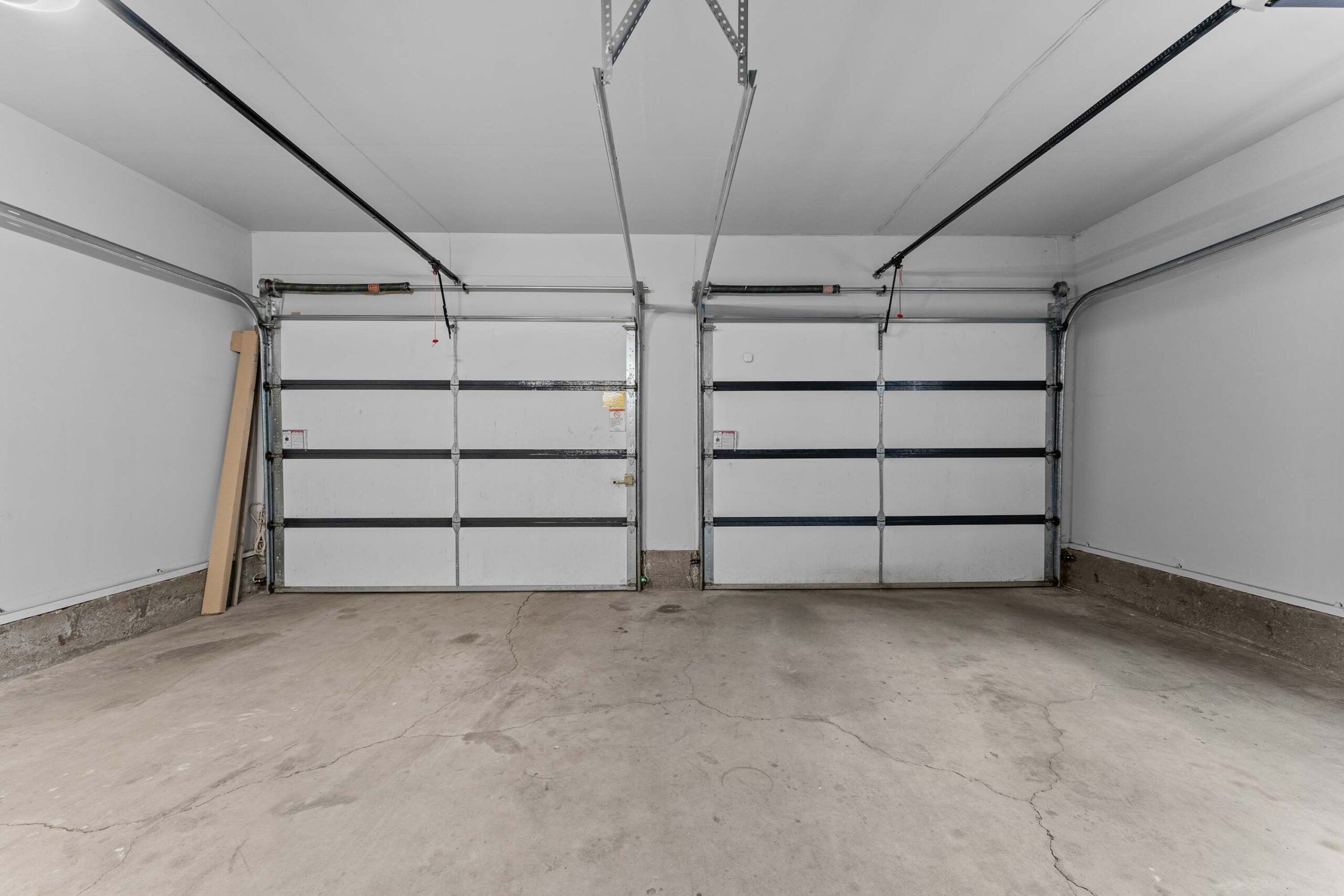 Empty garage space in a Truckee vacation rental with two large doors and concrete flooring.