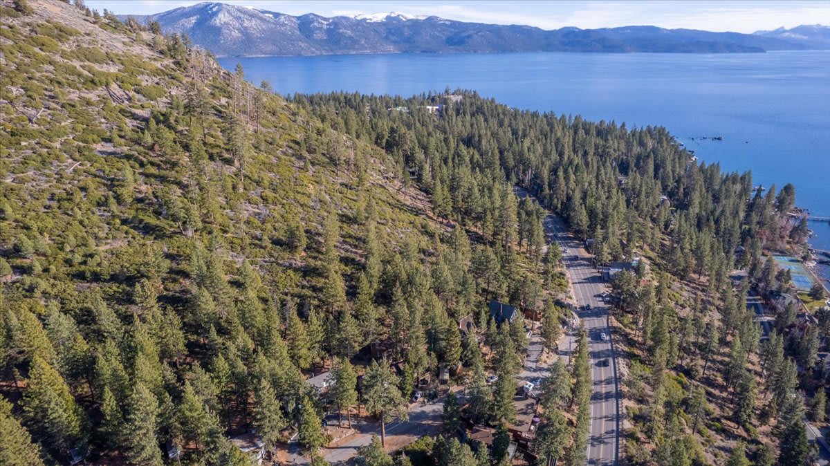 Aerial view of a vacation rental in Kings Beach, surrounded by pine trees with a lake in the background.