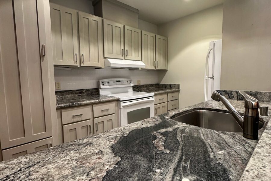 Modern kitchen in Kings Beach vacation rental with sleek granite countertops and white cabinets.