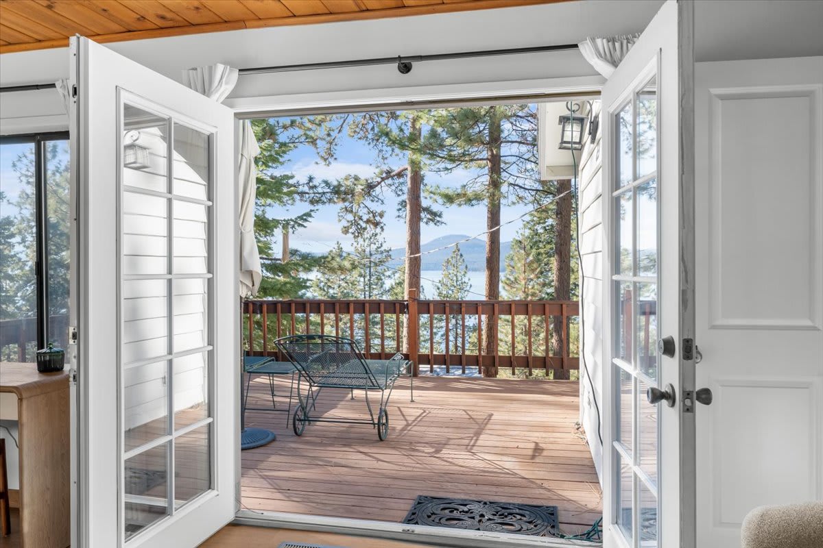 Open doors lead to a scenic deck with lake views in a Kings Beach vacation rental.