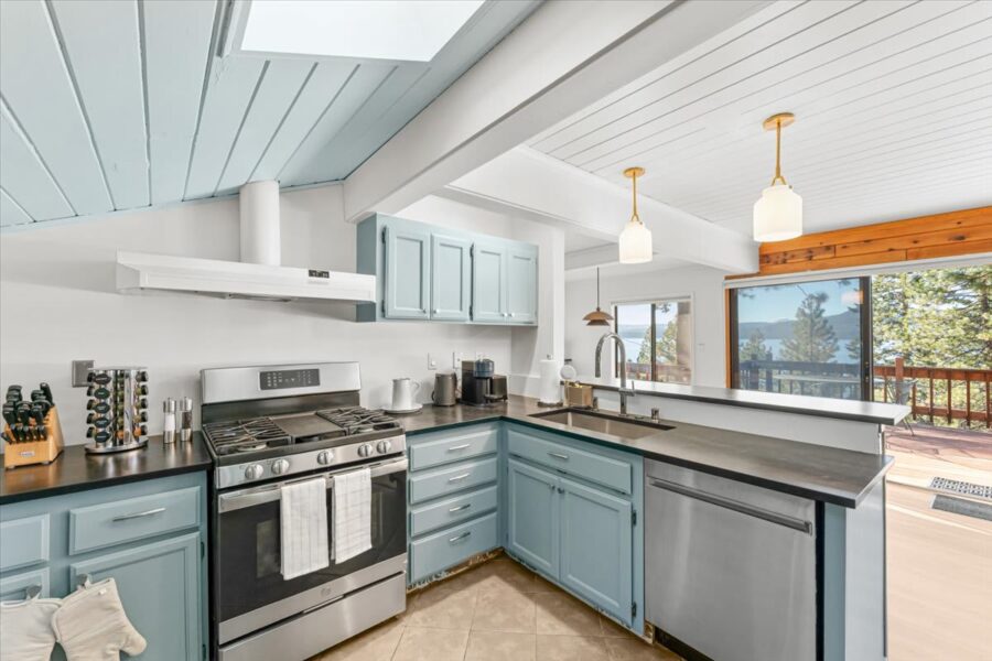 Modern kitchen in a Kings Beach vacation rental, featuring light blue cabinets and a scenic view from the window.