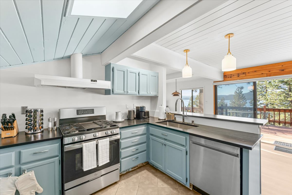 Modern kitchen in a Kings Beach vacation rental, featuring light blue cabinets and a scenic view from the window.