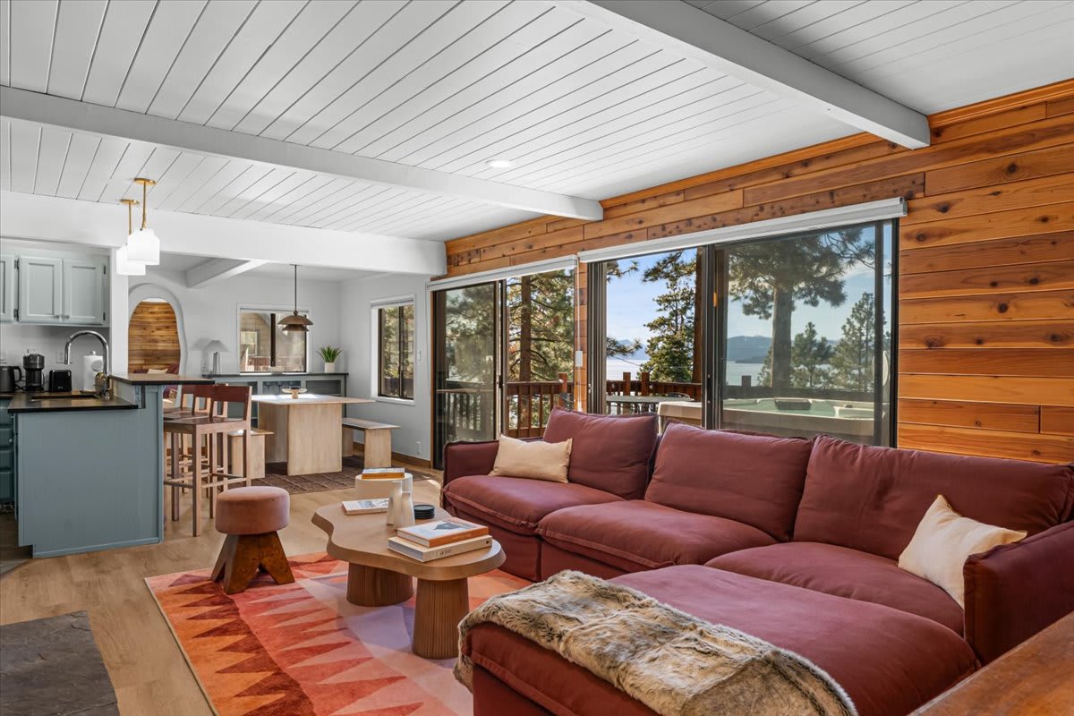 Stylish vacation rental in Kings Beach with cozy living area, red sofa, lake view, and modern kitchen.