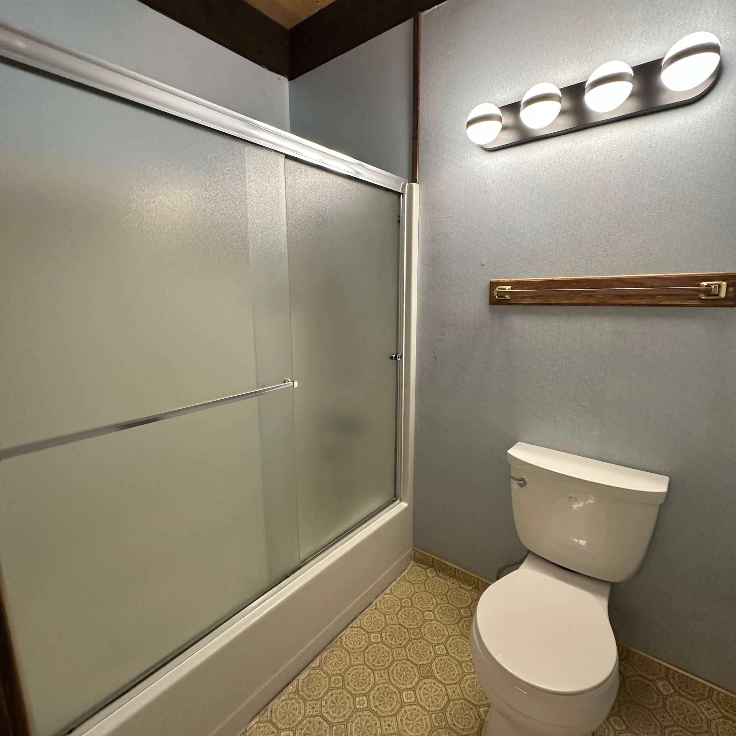 Bathroom in a Kings Beach vacation rental, featuring a shower with frosted glass doors and a toilet.