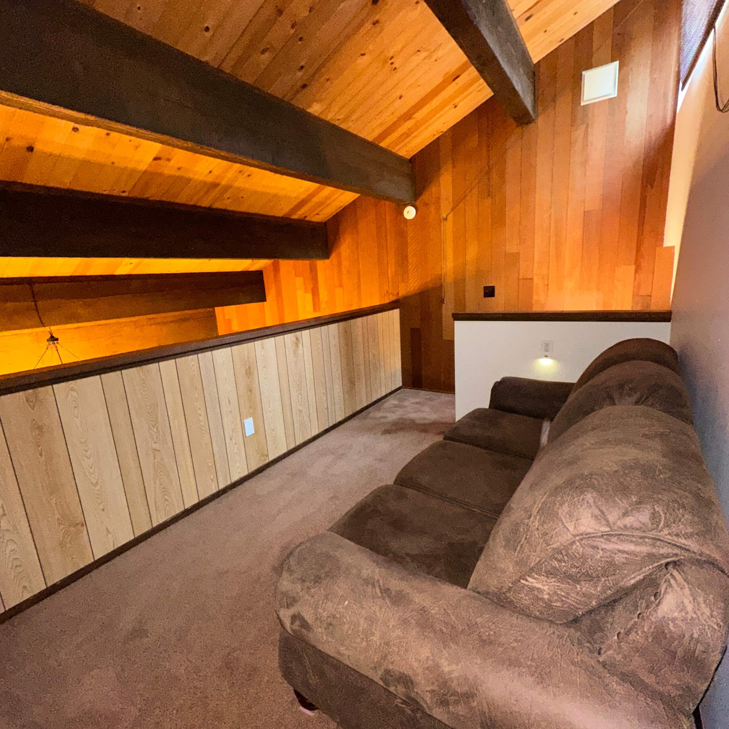 Cozy loft area with brown sofa and wooden walls in a Kings Beach vacation rental.