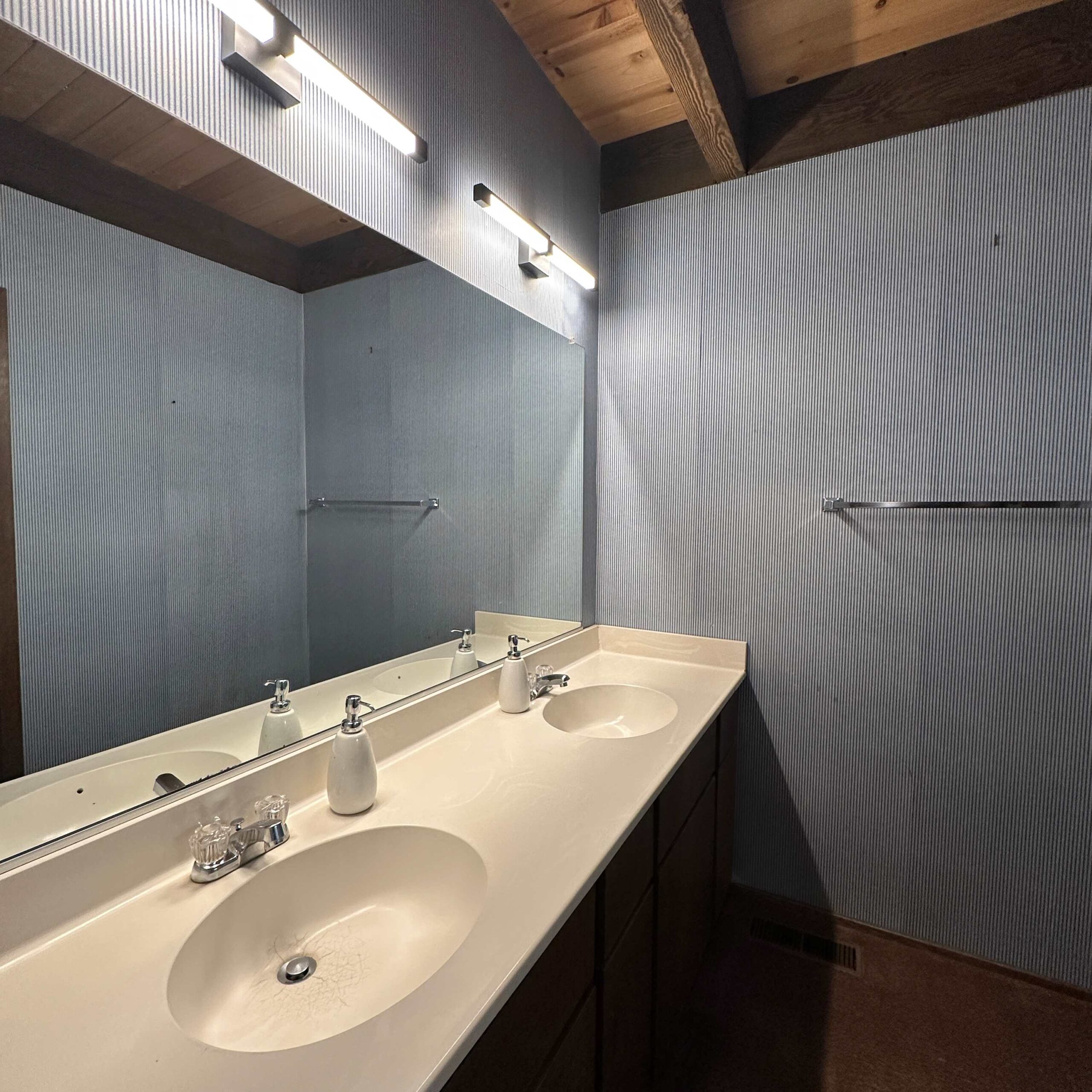 Kings Beach vacation rental bathroom with a double sink, large mirror, and modern lighting.