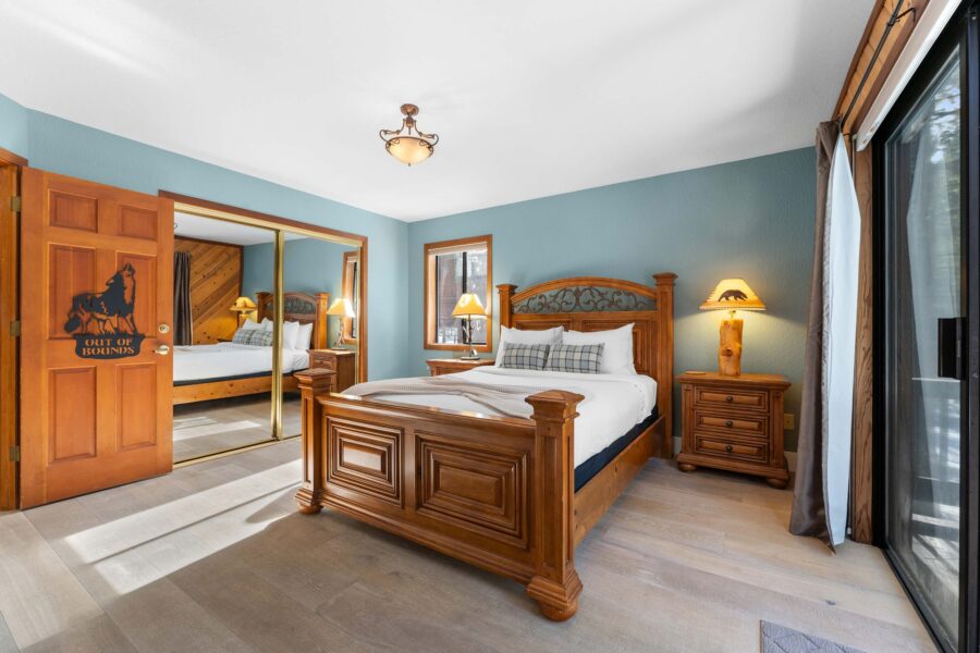 Rustic bedroom in Truckee vacation rental with wooden bed, mirrored closet, and nature-themed decor.