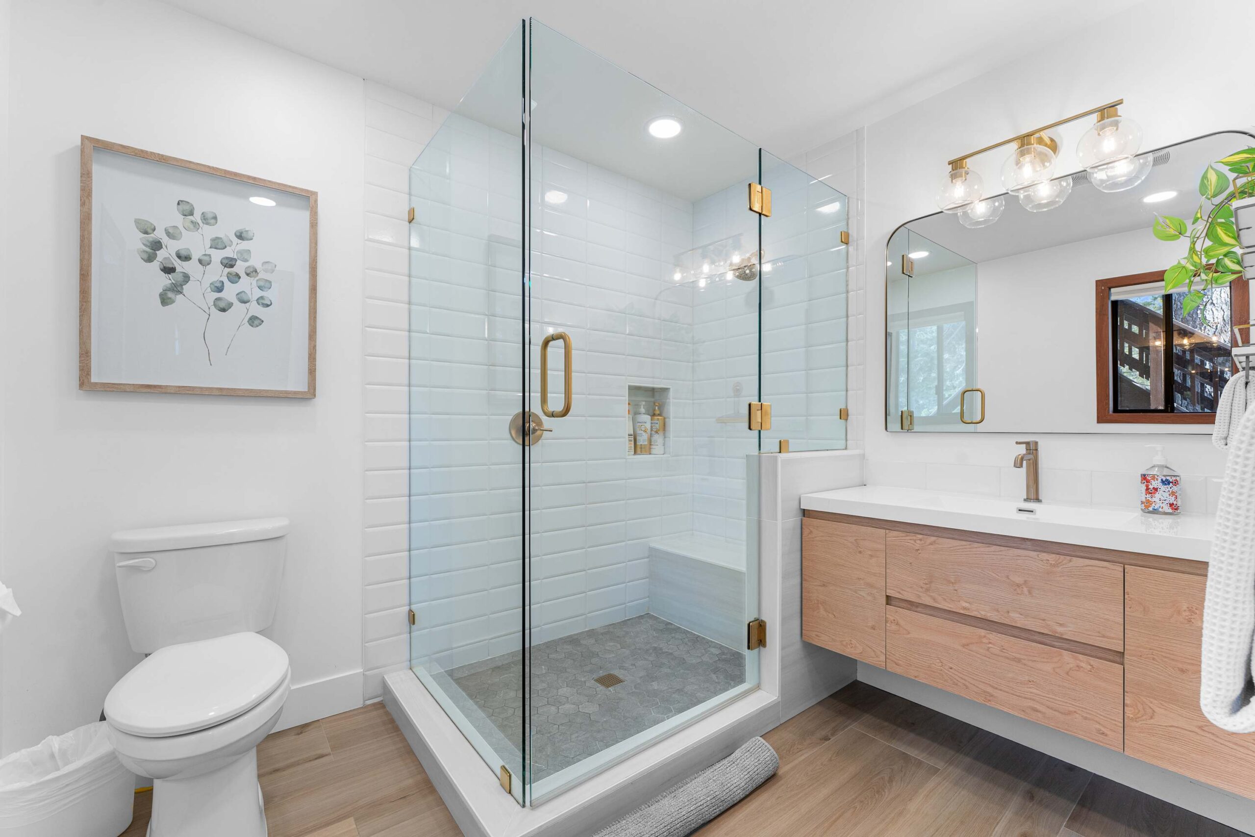Modern bathroom in Truckee vacation rental, featuring a glass-enclosed shower, vanity, and wall art.