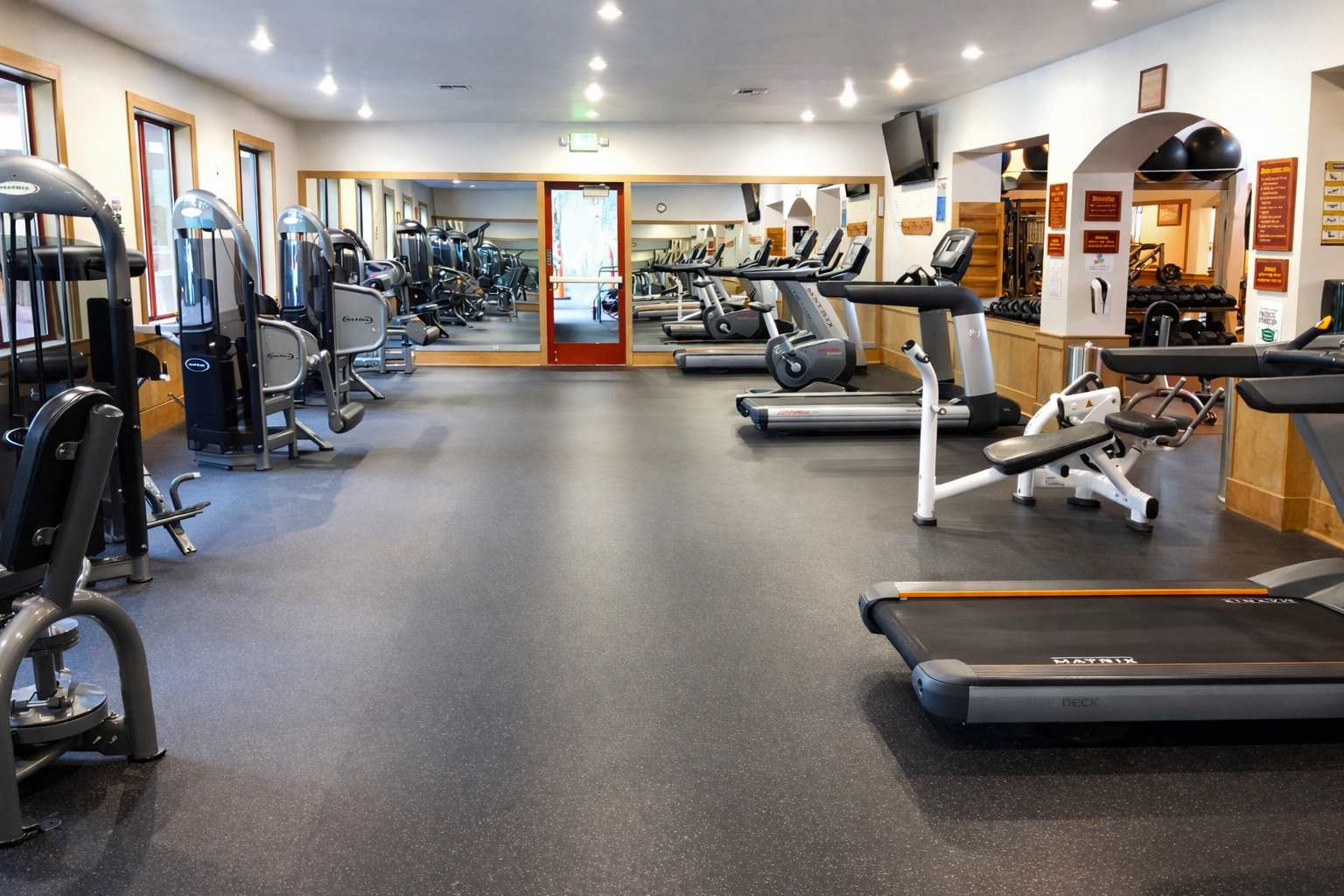 Modern gym in a Truckee vacation rental with treadmills, exercise machines, and mirrored walls.