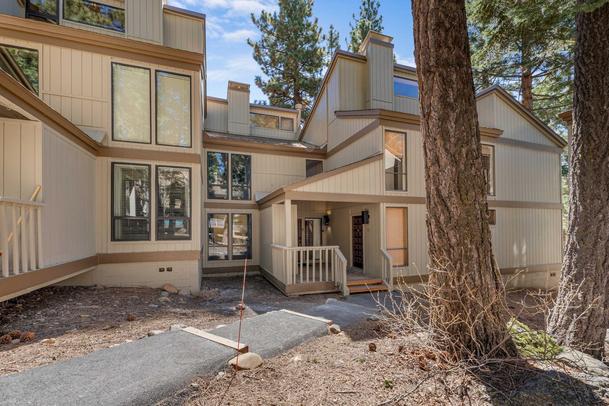Modern vacation rental in Kings Beach, featuring large windows and surrounded by trees.