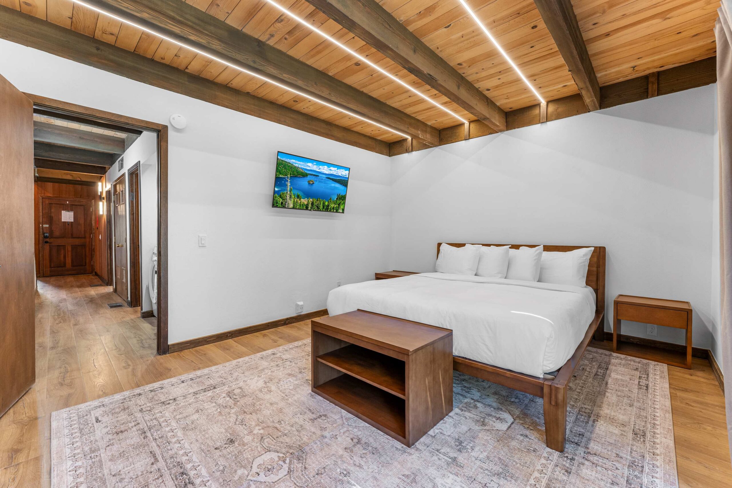 Spacious bedroom in a modern Kings Beach vacation rental with wood accents and a mounted TV.