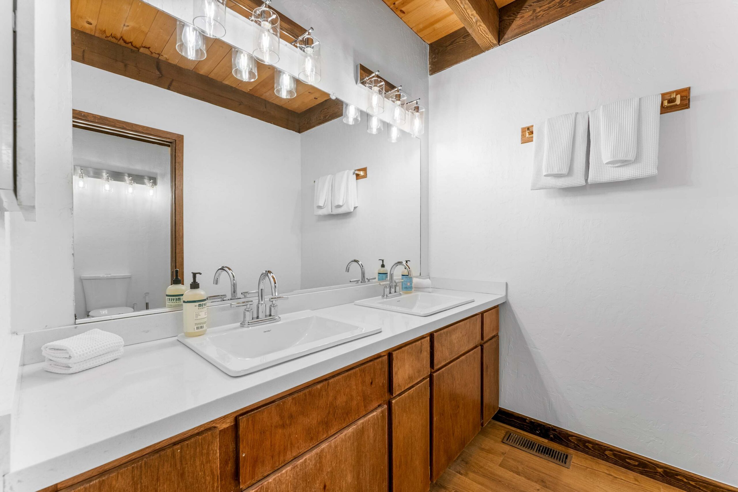 Double-sink bathroom in a Kings Beach vacation rental with wooden cabinets and bright lighting.