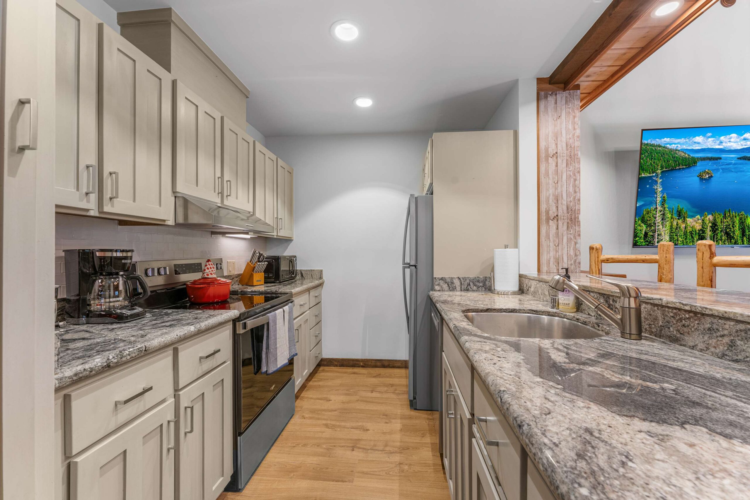 Modern kitchen in a Kings Beach vacation rental with granite countertops, light cabinets, and stainless steel appliances.