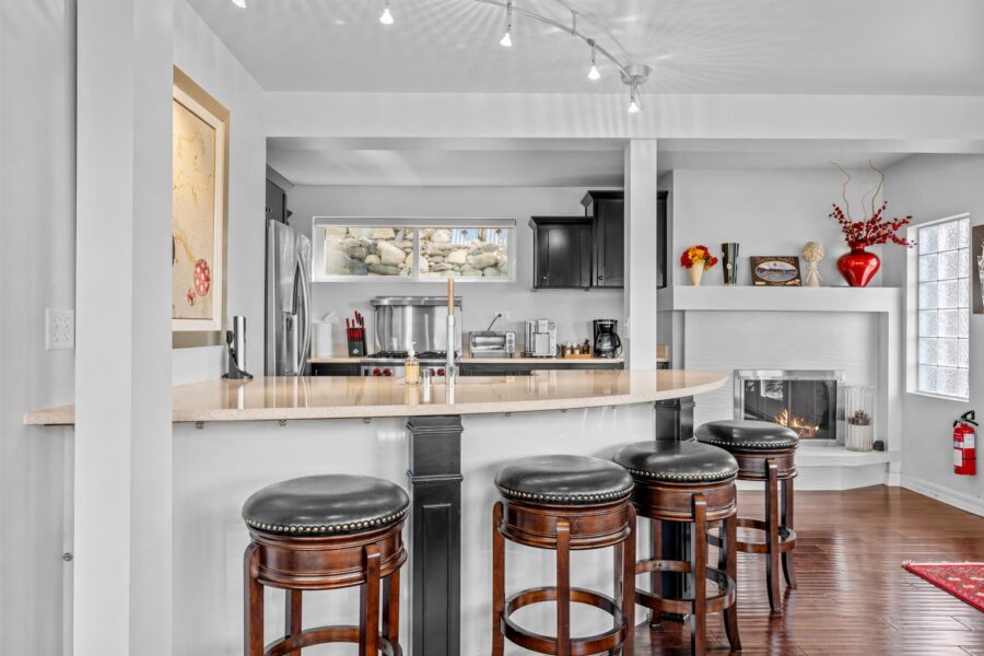 Stylish kitchen in a Kings Beach vacation rental with bar stools, modern appliances, and a cozy fireplace.