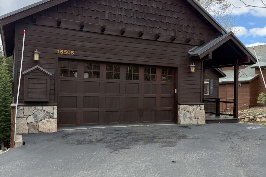 Rustic brown vacation rental with stone accents in Truckee, under cloudy skies, featuring a large garage.