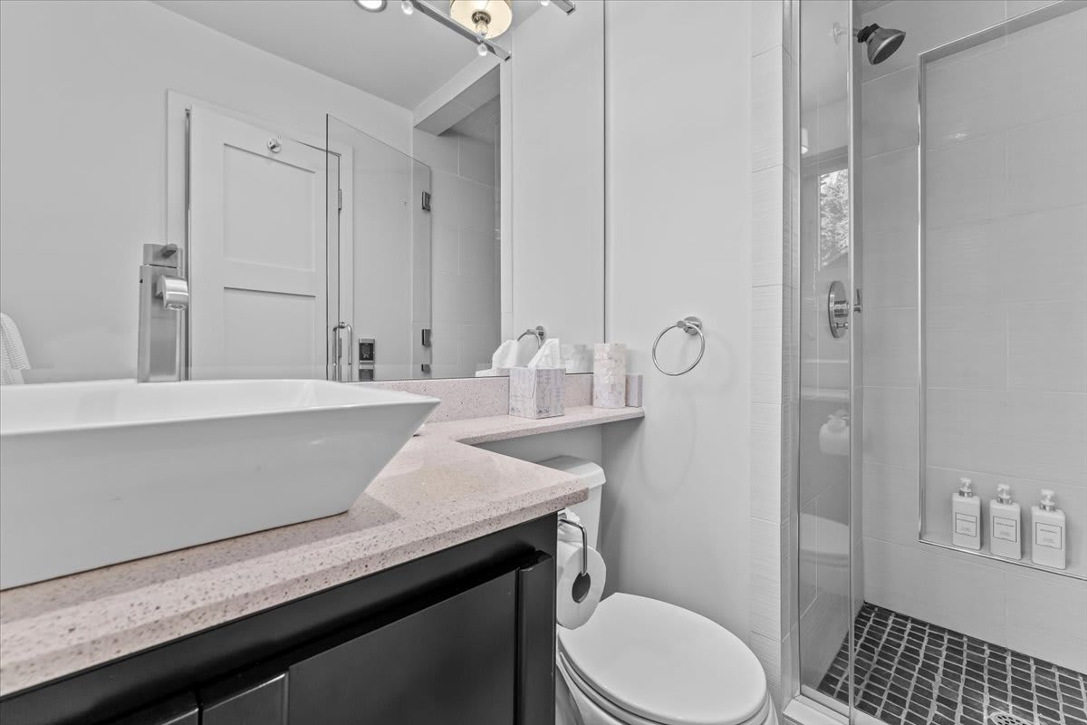 Modern bathroom in a Kings Beach vacation rental; features a vessel sink, glass shower, and elegant decor.