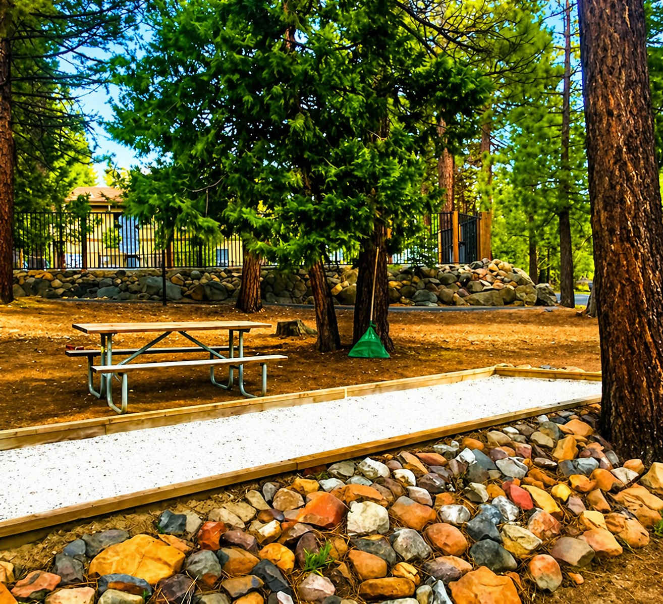 Picnic table among trees in a Kings Beach vacation rental, with a bocce court and stone landscaping.
